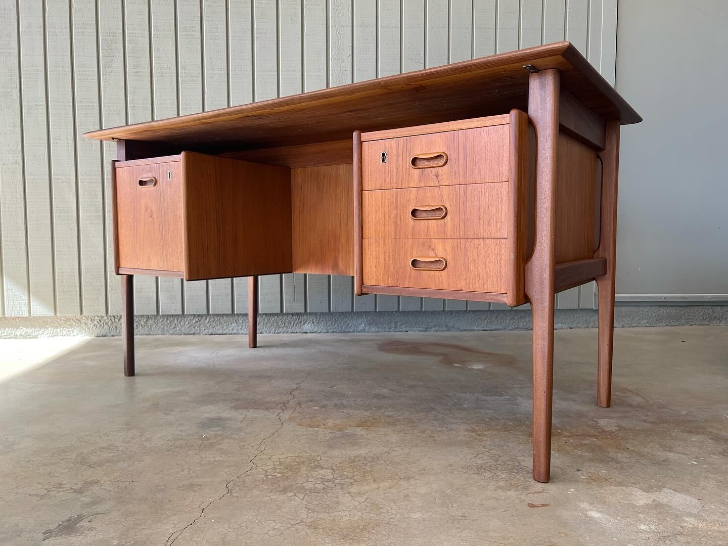 1960s Danish teak wood desk. Excellent mid century modern floating style with sculptural legs and handles. Features three drawers on the right and a filing drawer on the left. There is also a fold down tray on the back along with two cabinet spaces,