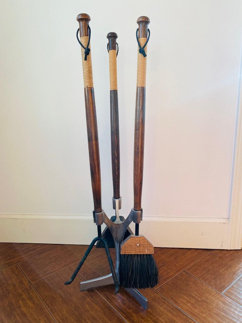 Gorgeous mid-century sculptural fireplace tool set with warm patinated walnut wood, raw iron, and papercord wrapped and leather handle accents. A complement to any fireplace, perfect for minimalist homes. In the style of Mid Century designer, Arthur
