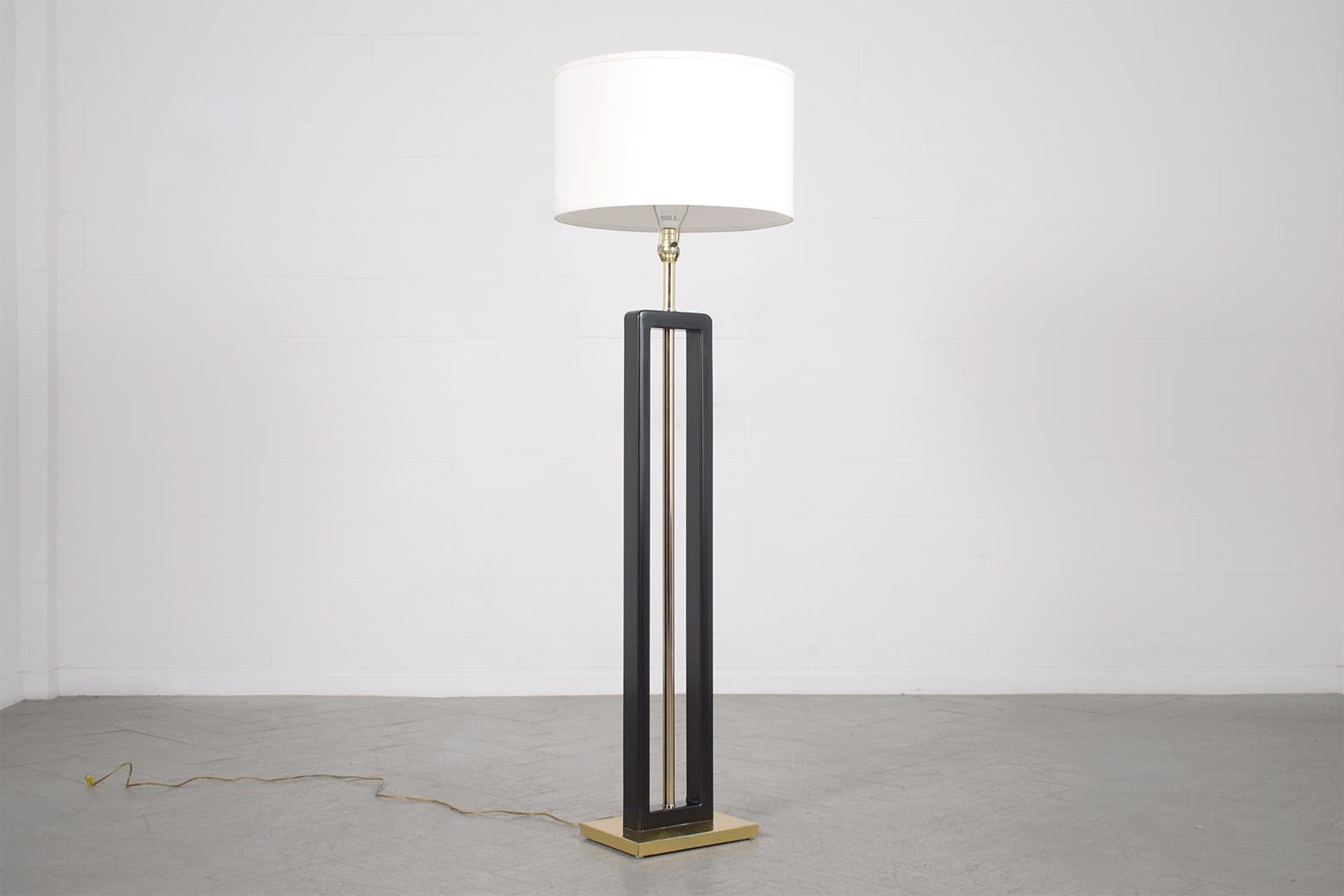 Our extraordinary vintage 1970s floor lamp, is expertly crafted from a blend of brass and metal. Maintained in excellent condition and recently restored by our in-house professional craftsman team, this mid-century modern lamp is sleek and