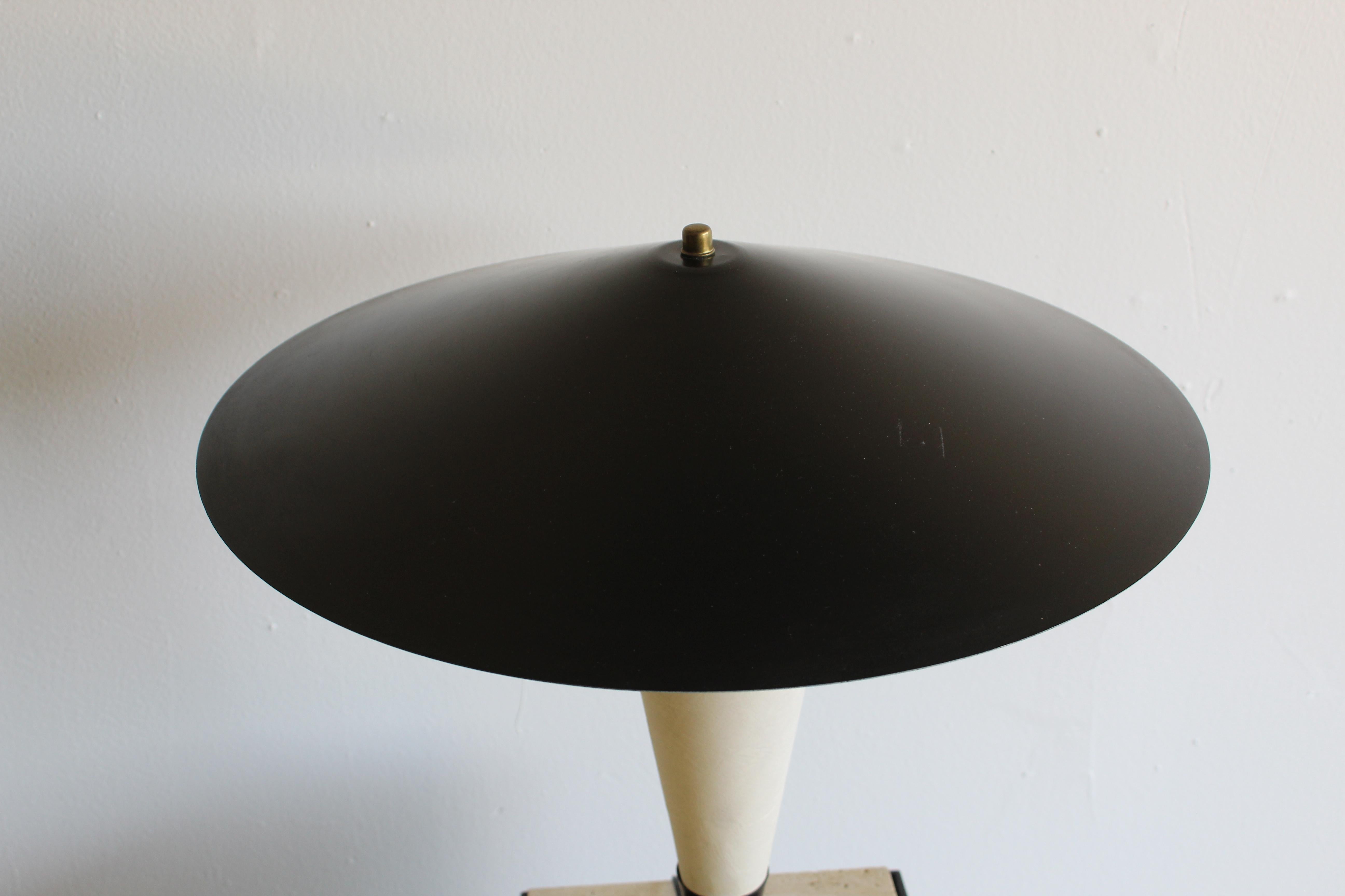 Vintage Mid Century Modern Flying Saucer Table Lamp
After Gerald Thurston c1970 
Flying saucer black and white table lamp after Gerald Thurston. Round black metal base and stem. White paper coated round center. Black metal shade with finial. One