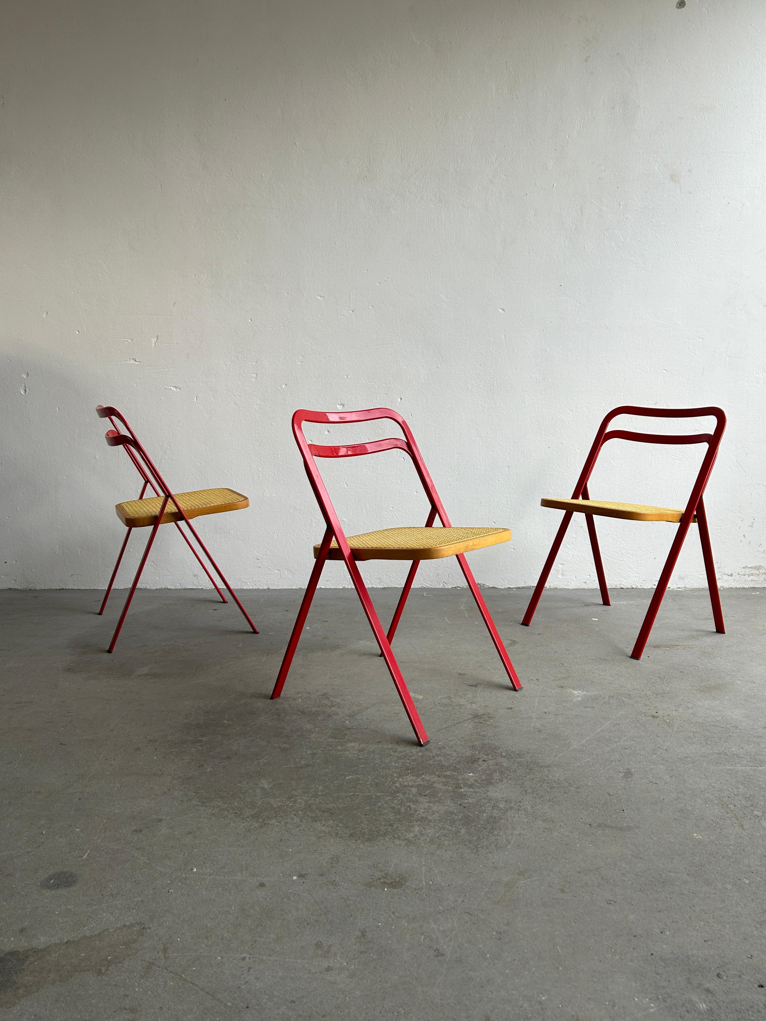 Set of 3 vintage folding dining chairs by CIDUE, designed by Giorgio Cattelan. They are made of steel frame lacquered in red colour with Vienna straw seats. Produced during the 1980s in Italy.
Modernist minimal Italian design.

Completely
