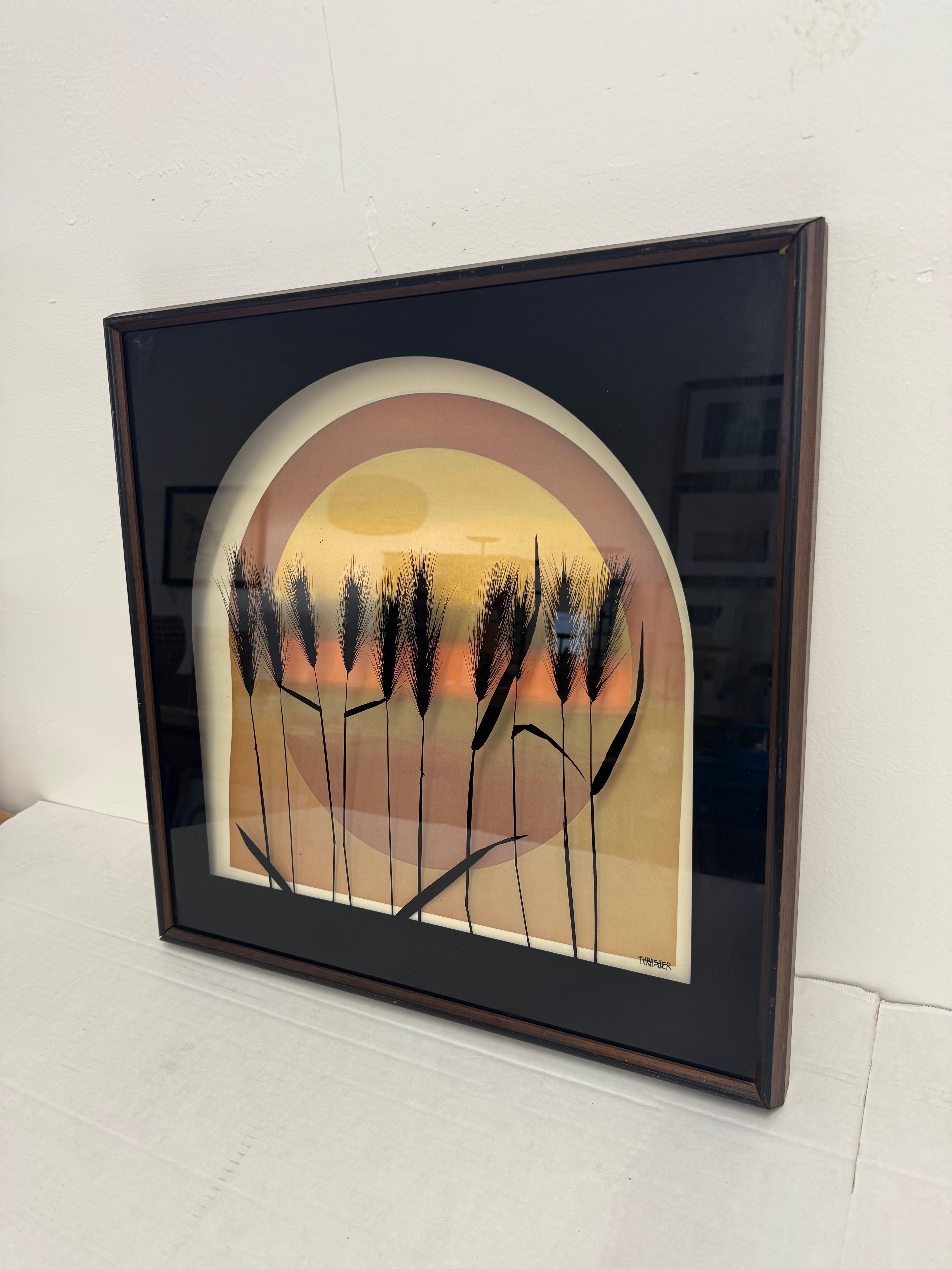 Cette superbe impression vintage encadrée capture toute la magie d'un coucher de soleil du milieu du siècle, avec des tons doux et dégradés, un design en arc superposé et de délicates silhouettes de blé. Estampillée par l'artiste ADS, cette pièce