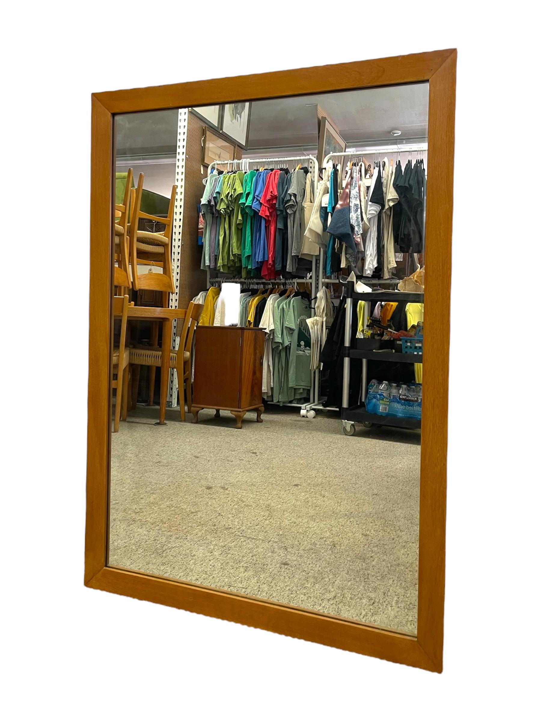 Miroir Vintage Mid-Century Modern présentant un cadre aux lignes épurées et minimalistes et un ton chaud brun doré. Les coins à onglet simples et la finition lisse soulignent l'élégance discrète typique du design d'inspiration scandinave. Cette