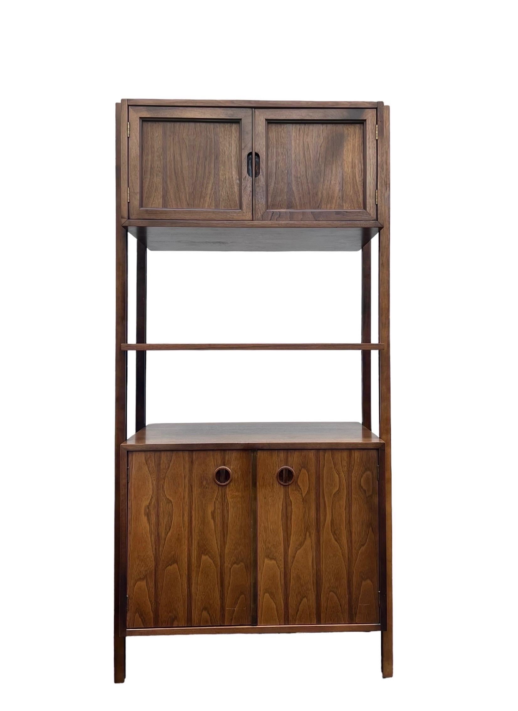 Rare 1-bay freestanding walnut wall unit by Stanley. This set is rare in its original form with cabinets and shelf. The bottom cabinet has a removable shelf. The height-wise location of the cabinets and the shelf are adjustable. This unit can be
