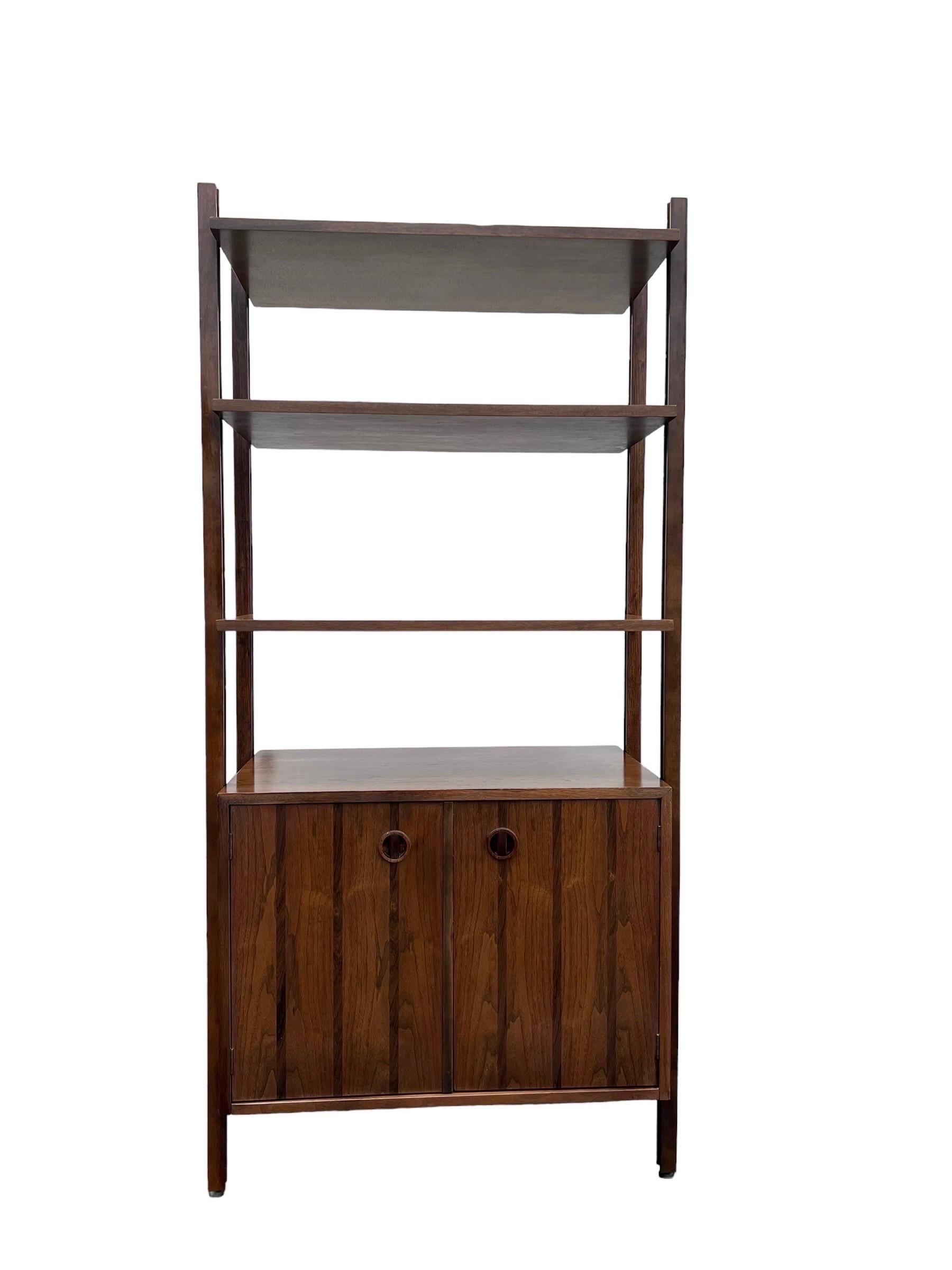 Rare 1-bay freestanding walnut wall unit by Stanley. This set is rare in its original form with cabinets and shelf. The bottom cabinet has a removable shelf. The height-wise location of the cabinets and the shelf are adjustable. This unit can be