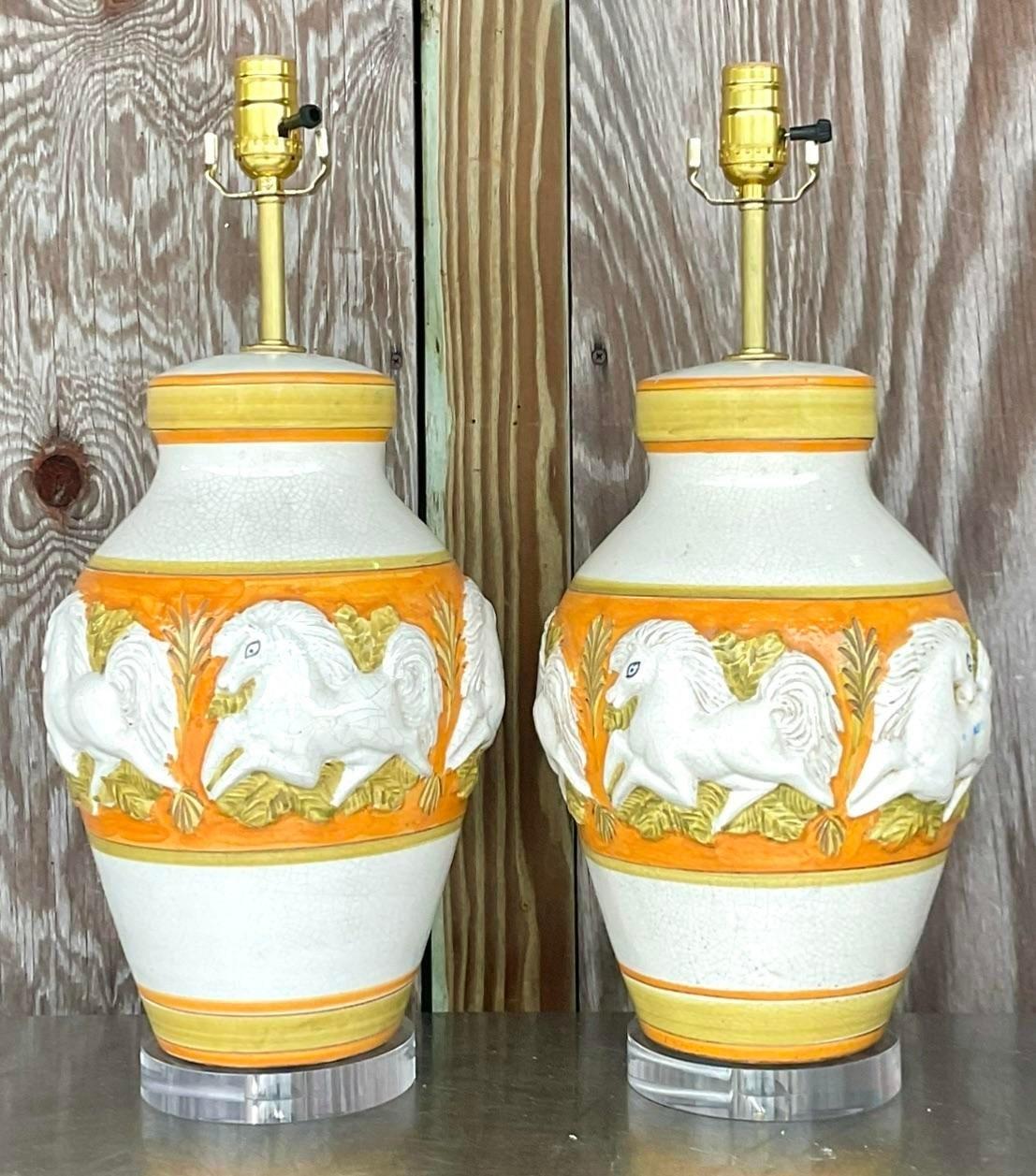 A fantastic pair of vintage MCM table lamps. A chic period relief prancing horse in a fabulous hand painted design. Brilliant colors. Fully restored with all new wiring, hardware and lucite plinth. Acquired from a Palm Beach estate.