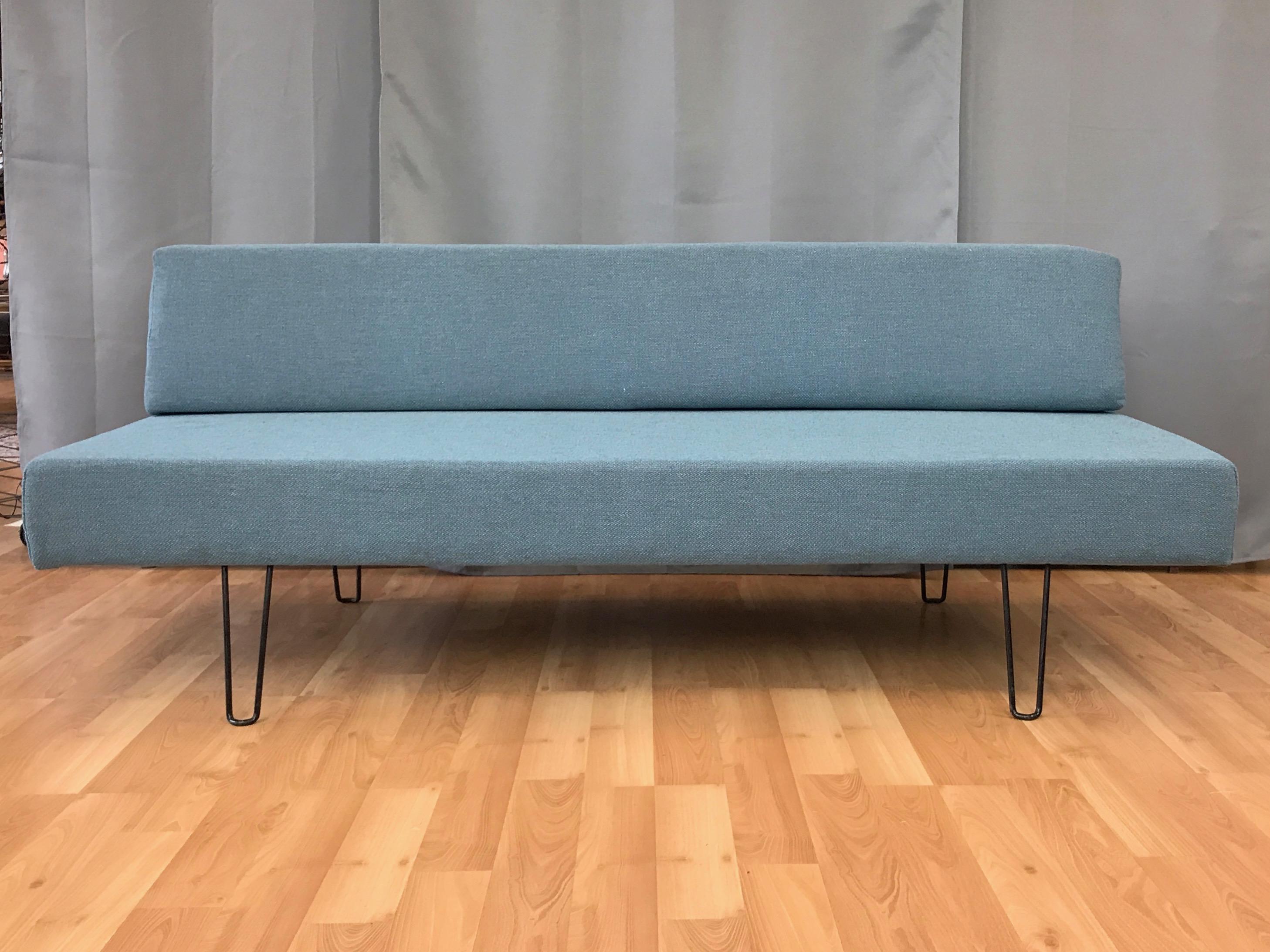 A 1950s Mid-Century Modern daybed or sofa with hairpin legs.

Minimalist form features a loose wedge back on a rectangular seat with internal wood frame. Crisply reupholstered in vintage cool-hued wool heather fabric over new high grade foam. Bent