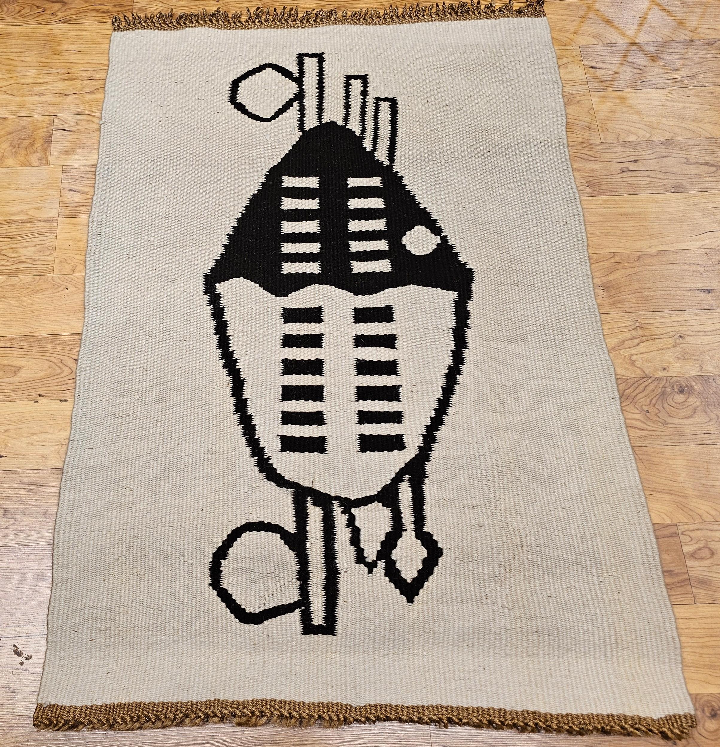 A distinctive piece of vintage Mid-Century Modern handwoven tapestry wall art, crafted in the mid-1900s, this textile work combines abstract form with symbolic design. The tapestry features a bold interpretation of a shield and arrows motif,