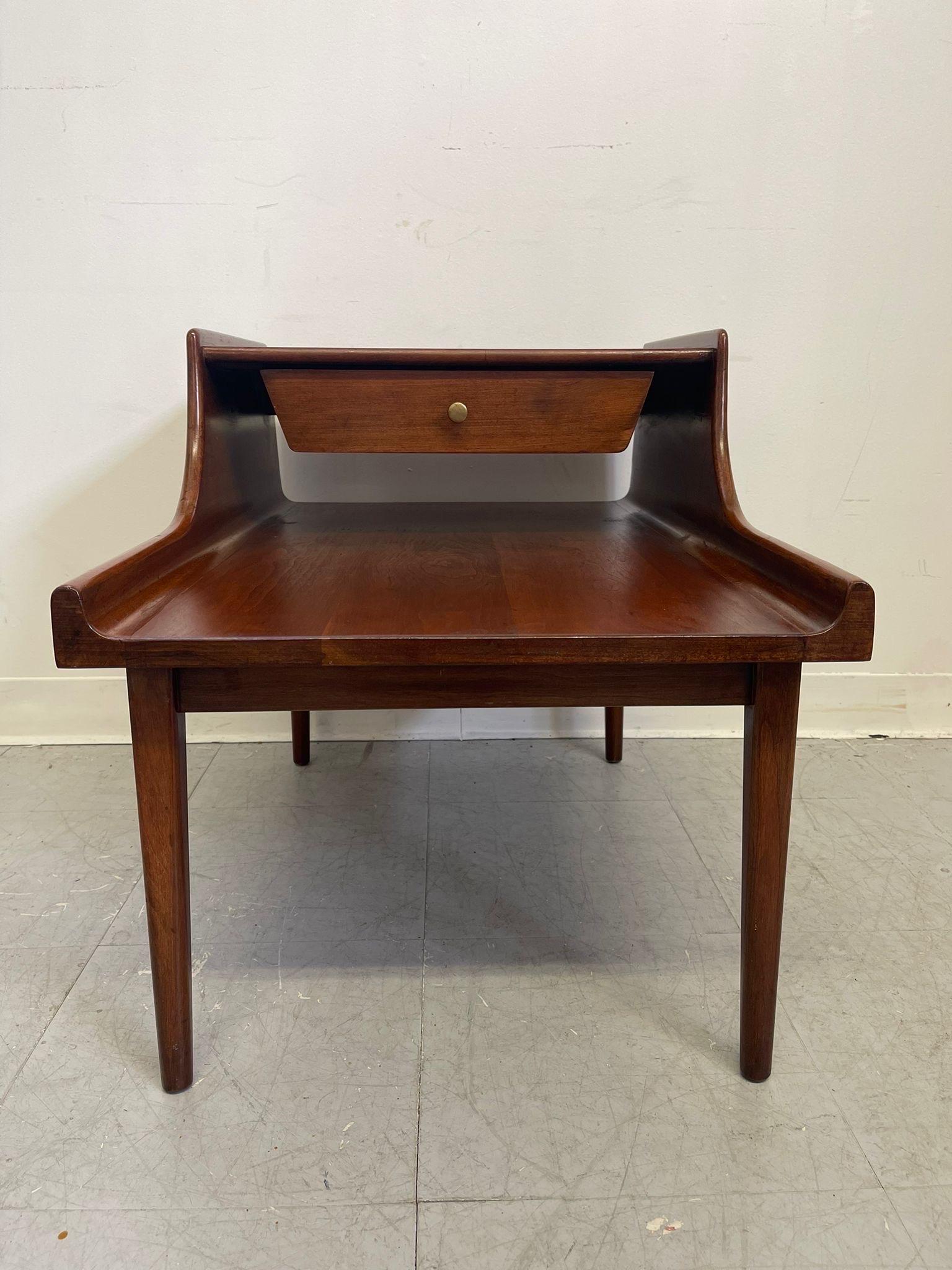 This End Table has beautiful sculpted wood Accents and walnut tone. Single dovetailed drawer with makers mark inside. Brass toned Hardware. Vintage Condition Consistent with Age as Pictured.

Dimensions. 29 W ; 20 D ; 15 H to first shelf
           