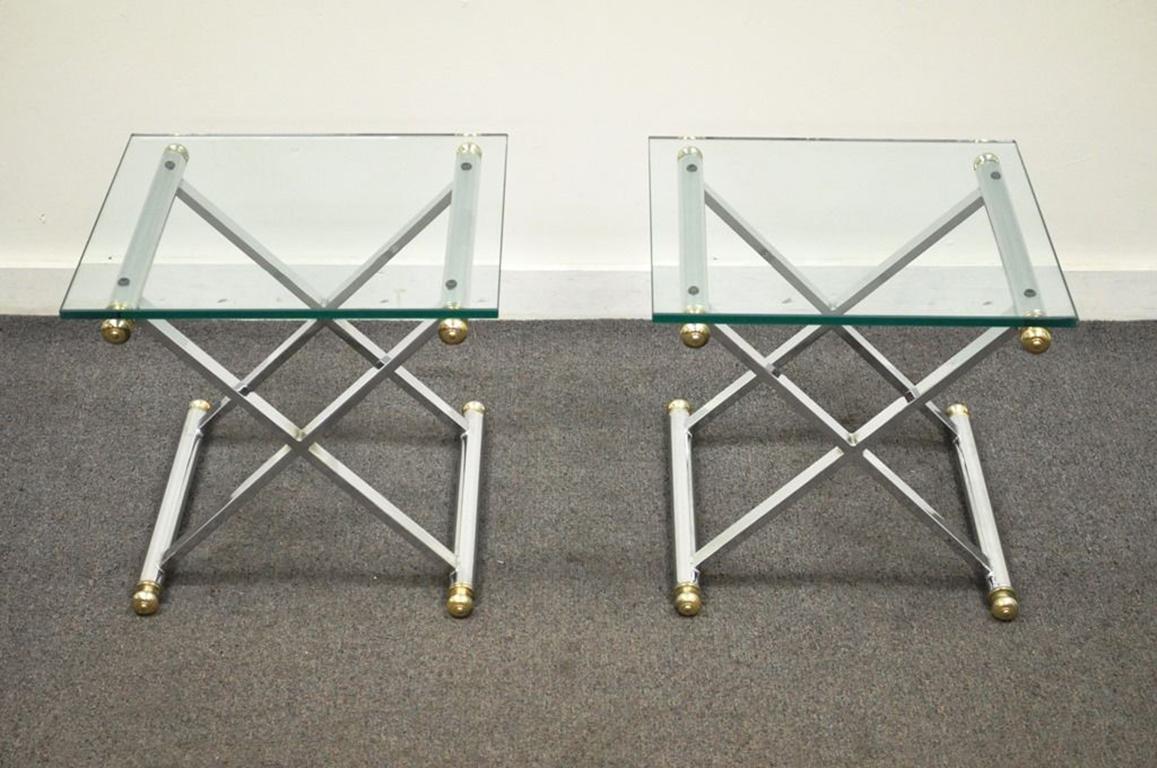 Pair of very striking vintage Mid-Century Modern/Hollywood Regency X-form chrome and brass glass top side tables. The tables feature a super sleek modern design with seamless joints, and thick glass tops, circa mid-late 20th century. Measurements: