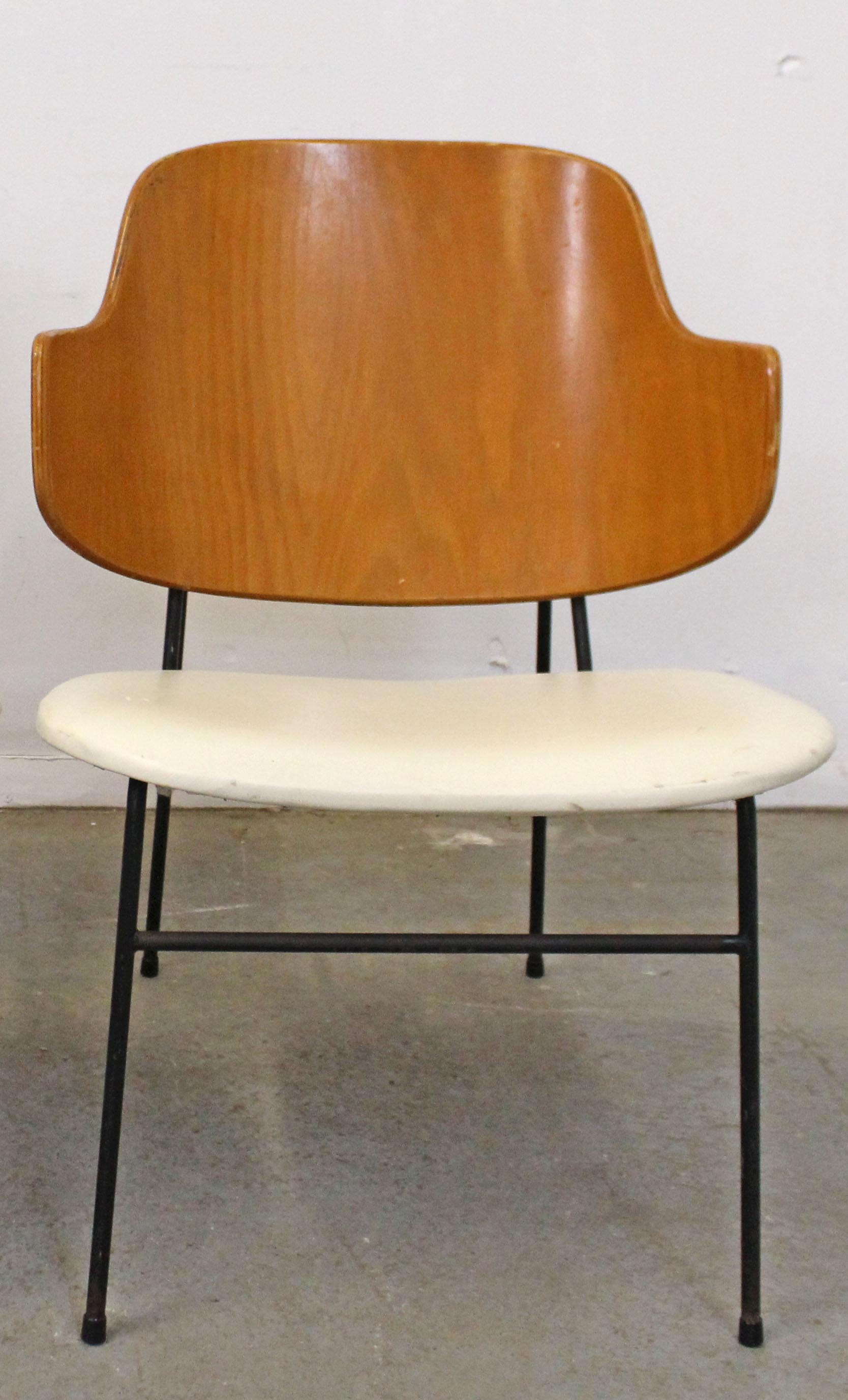 What a find. Offered is an original 'Penguin' chair designed by IB Kofod Larsen for Selig. This piece was designed in 1953 and had a limited production through the 1960s. This chair has a wood back and vinyl seat. In good, structurally sound