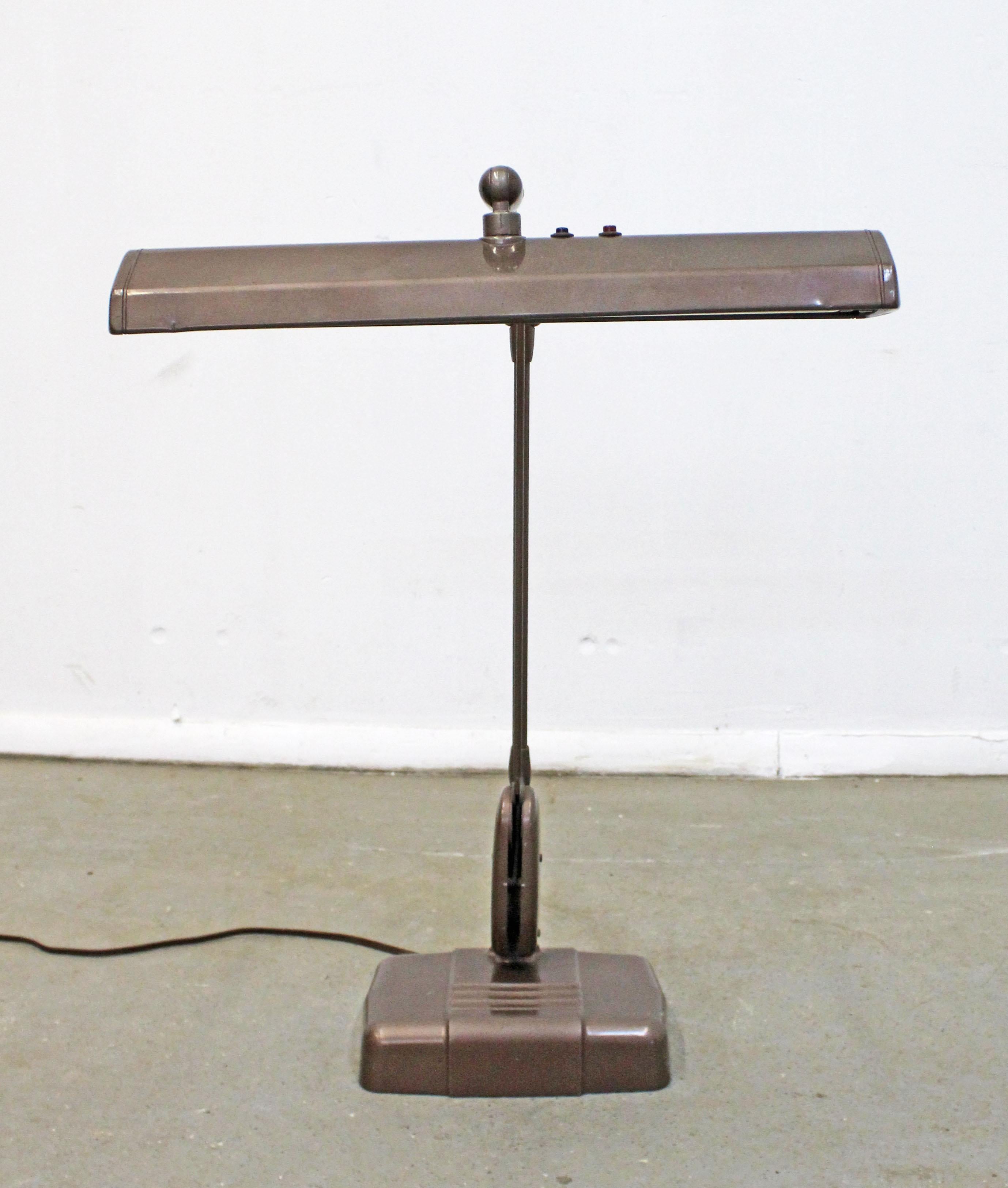 Offered is a vintage midcentury Industrial style table lamp by Dazor Mfg Corp. Perfect for a drafting table or desk. This lamp features a weighted base, adjustable head and an articulating arm that allows it to raise, lower or extend out. In good