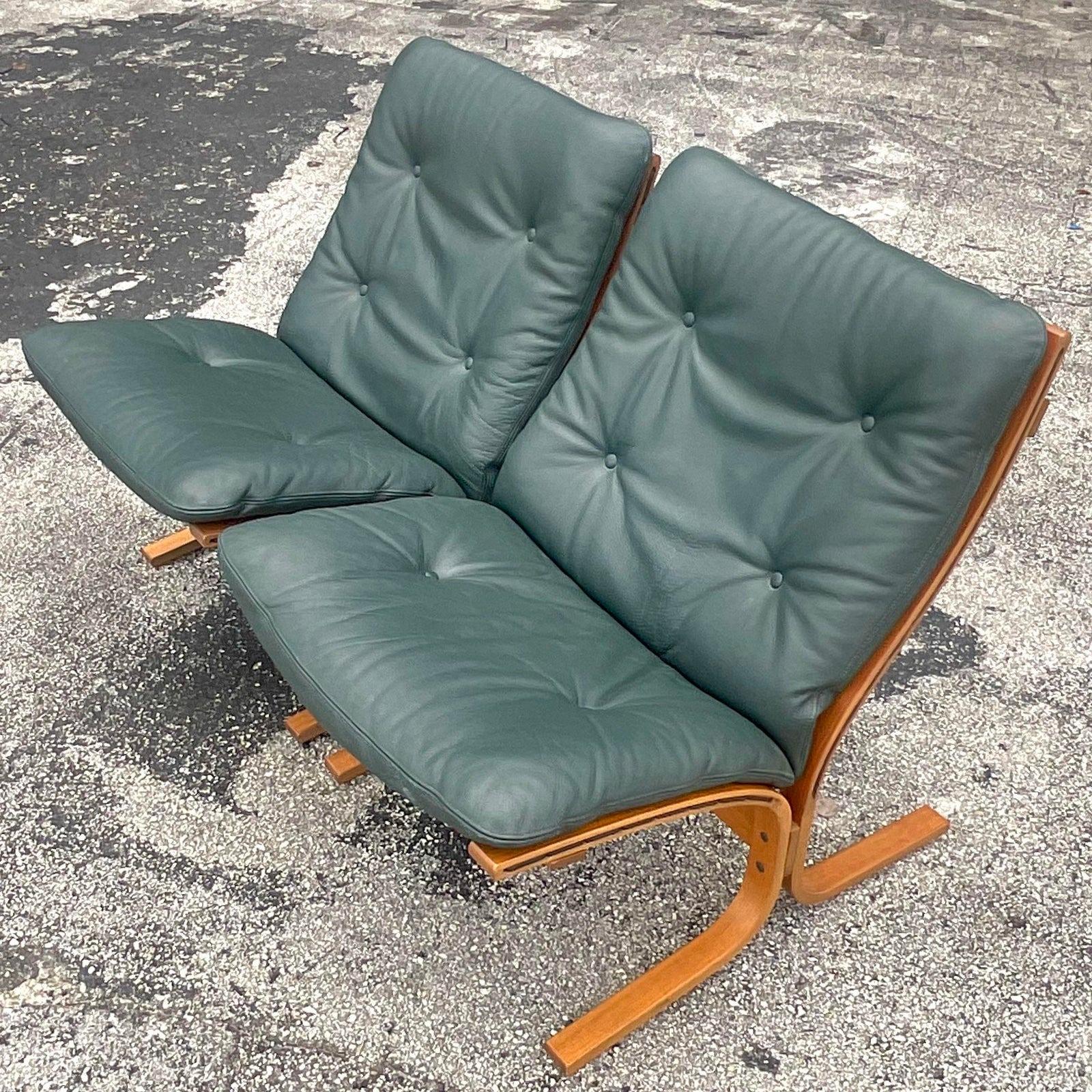 A fabulous pair of vintage MCM “Siesta” lounge chairs. The coveted sling chair by Ingmar Relling for Westnofa. Tagged on the bottom. Beautiful Hunter green leather tufted cushions. Acquired from a Palm Beach estate.
