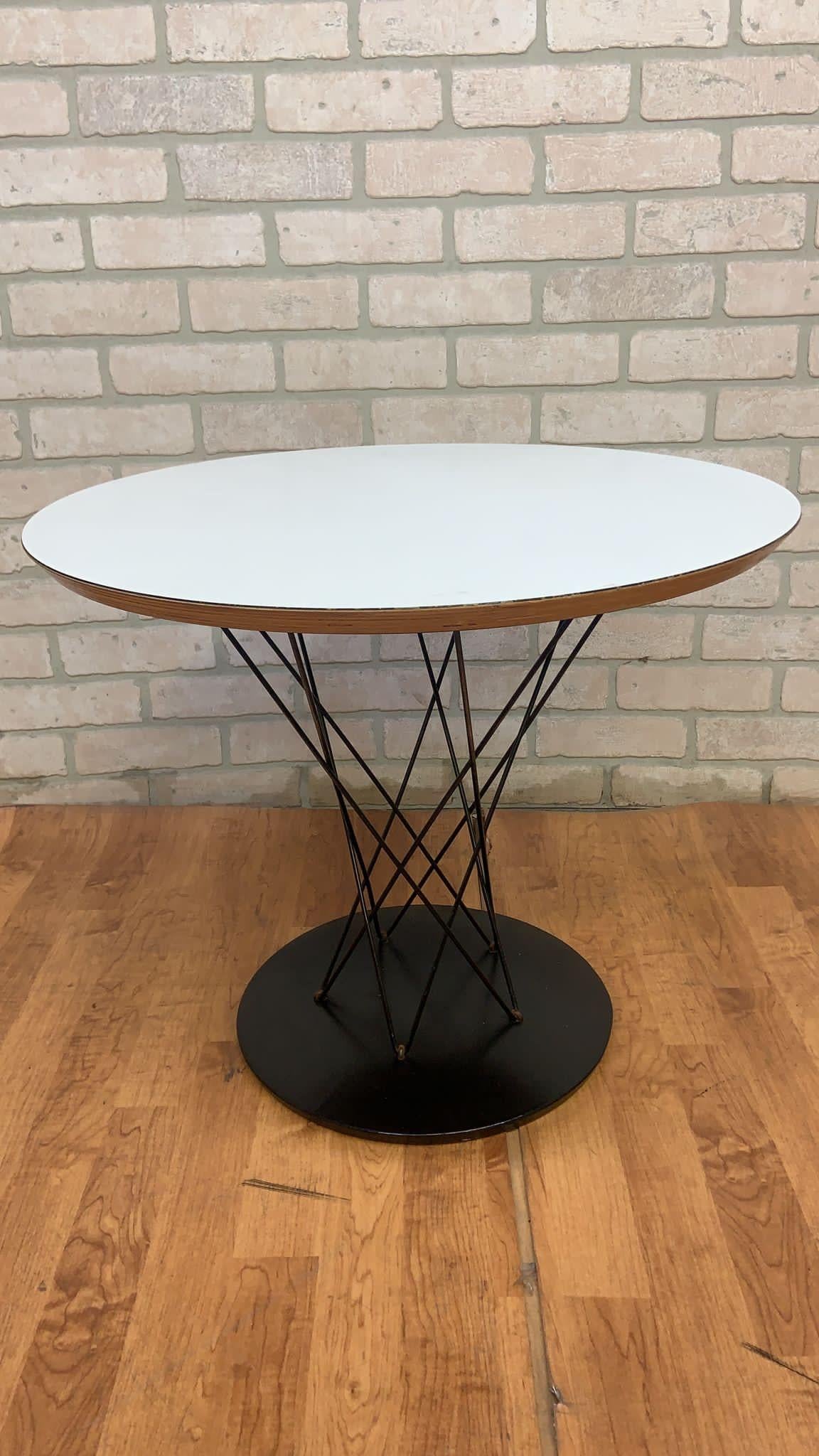 Vintage Mid Century Modern Isamu Noguchi Cyclone Side Table

This mid century modern side table has an eye-catching steel wire silhouette and cast-iron black base. The top is a birch plywood with a white laminate finish and a natural birch