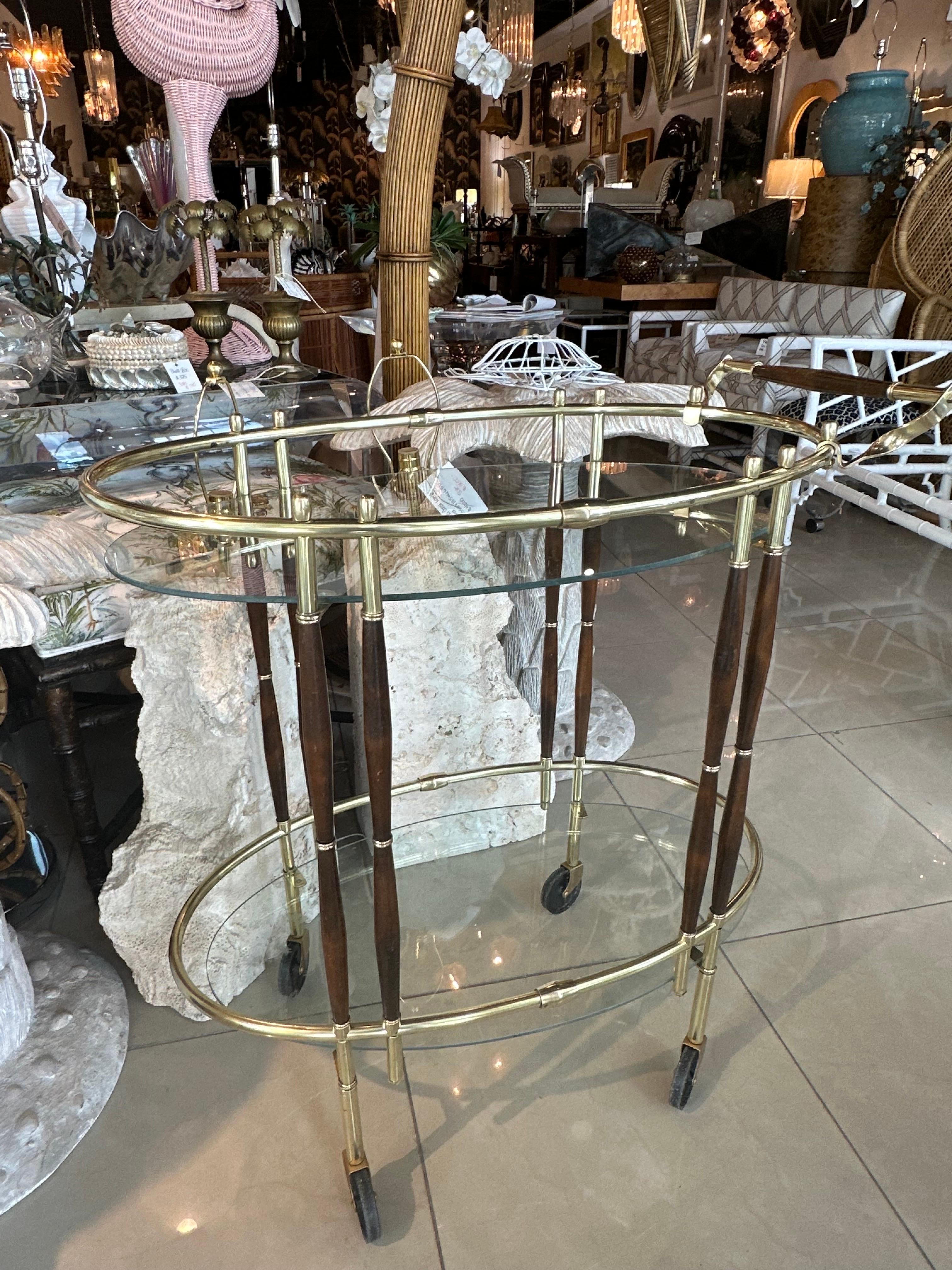 Vintage 1950s Italian oval bar cart avec bois de noyer et laiton, étagères en verre à deux niveaux. Les vitres du haut et du bas seront neuves. Elle a été polie mais présente une patine normale sur le laiton et le bois. Dimensions : 33,5 H x 31,5 L