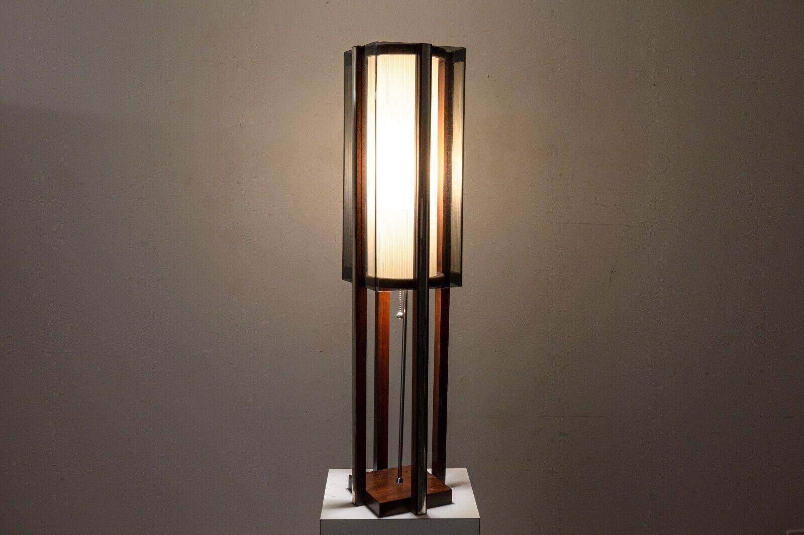 A vintage mid century modern large table lamp. This beautiful table lamps features a lovely mcm design with a great choice of materials such as a walnut wood frame, smoked lucite shades, and chrome accents. This piece gives off a wonderful warm
