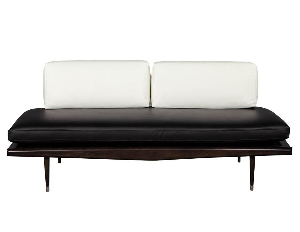 Vintage Mid-Century Modern leather sofa. Recently restored in an espresso finish with a black leather base cushion and white leather backrest cushions.

Price includes complimentary scheduled curb side delivery service to the continental USA.