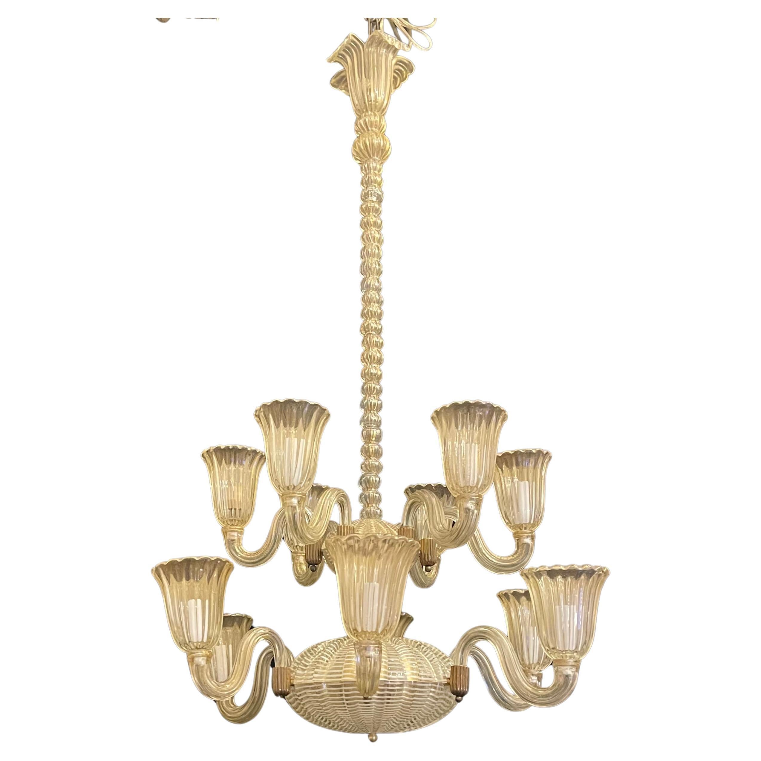 A Wonderful Vintage Mid-Century Modern Retailed By Lorin Marsh, Gold Flake and Ribbed Murano Blown Art Glass Chandelier Rewired With 12 Candelabra Lights In The Style Of Barovier Seguso & Ferro
One Arm Under The Cup Has Been Professionally