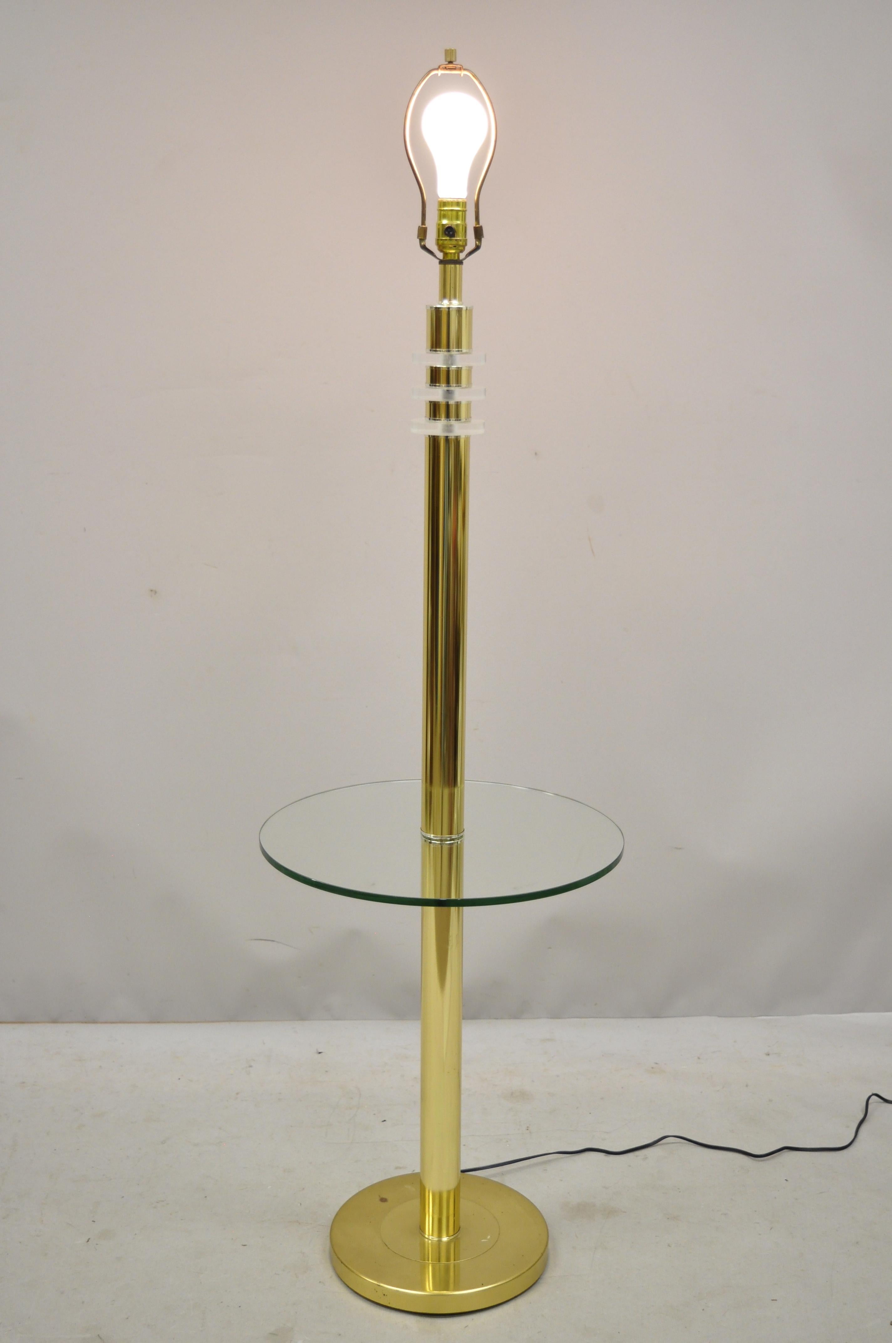 Vintage Mid-Century Modern Lucite brass glass pole floor lamp side table (A). Item features 3-way switch, Lucite accents, brass frame, round glass table top surface, clean Modernist lines, great style and form, circa mid-late 20th century.