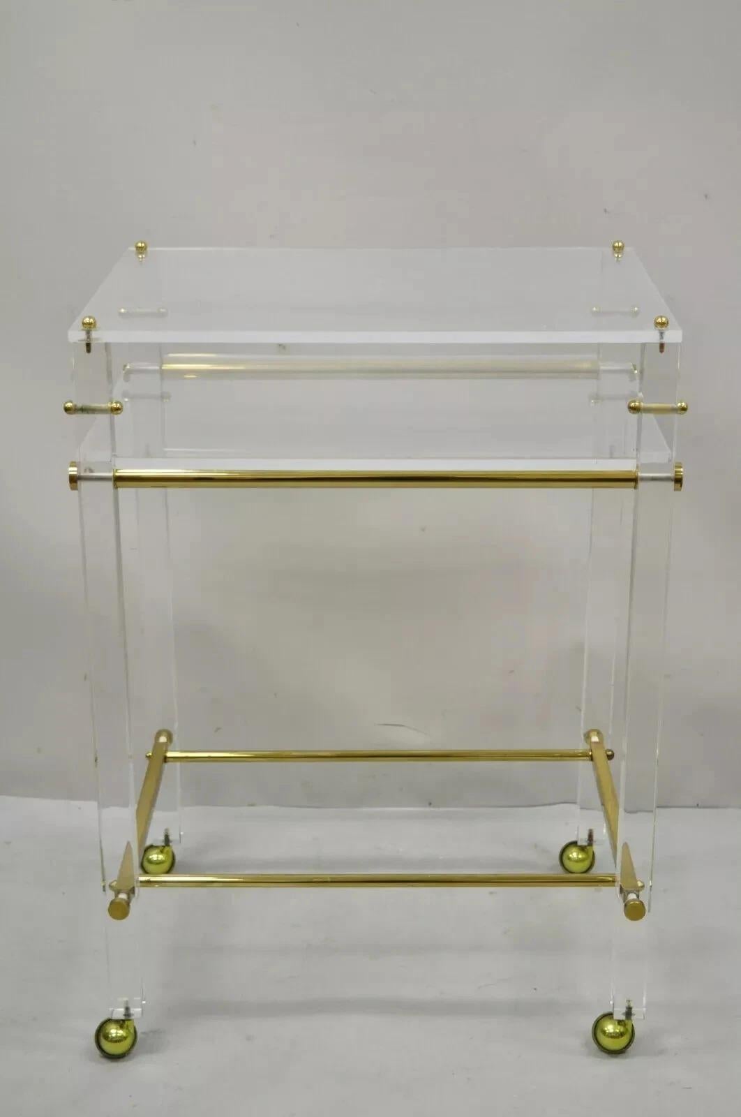 Vintage Mid Century Modern Lucite & Brass Rolling Bar Cart Tall Side Table. Cet article se caractérise par une base en laiton, des roulettes, un niveau supérieur en lucite avec une étagère, des lignes modernistes épurées, un style et une forme