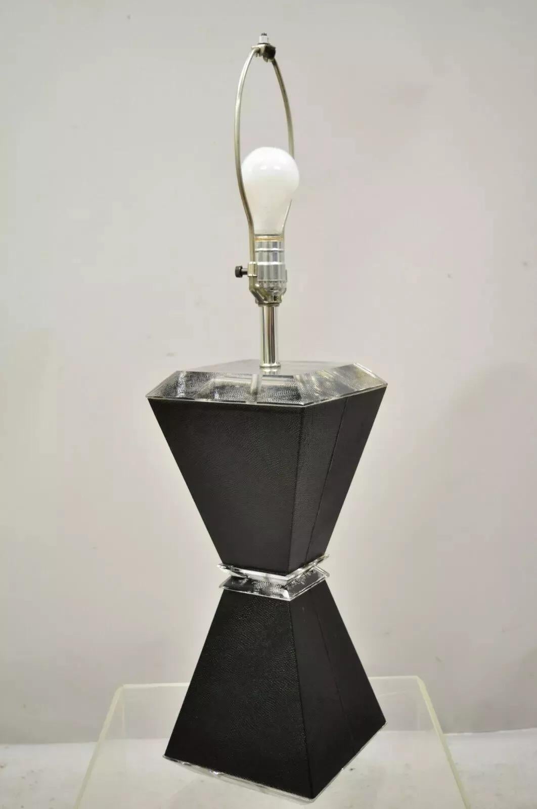 Lámpara de Sobremesa Vintage Mid Century Modern Lucite Reloj de Arena Negro Piel de Tiburón de imitación. El artículo presenta un cuerpo de reloj de arena de imitación de piel de tiburón negra texturizada, detalles de lucita, líneas modernistas