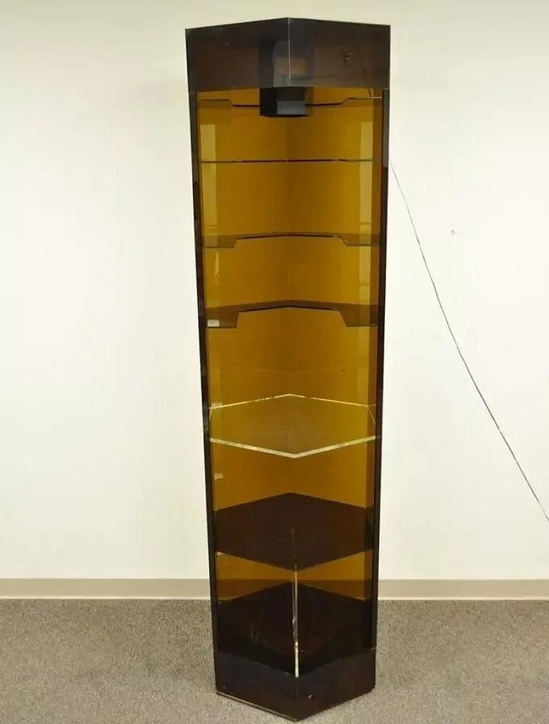Vintage Mid Century Modern Lucite Lighted Revolving Tall Narrow Retail Display. Item features a tall case sitting on a revolving base with 7 levels of shelving and lights that shine up and down as pictured. Circa Late 20th Century. Measurements: