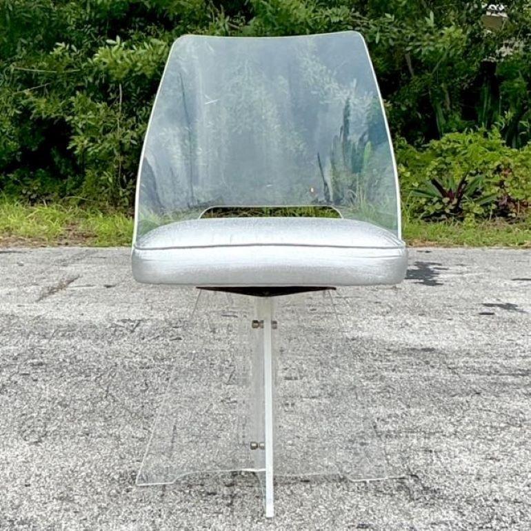 Add a touch of mid-century modern elegance to your space with this Vintage MCM Lucite Swivel Chair, inspired by the iconic designs of Charles Hollis Jones. This chair features a sleek, transparent Lucite frame that creates an airy and contemporary