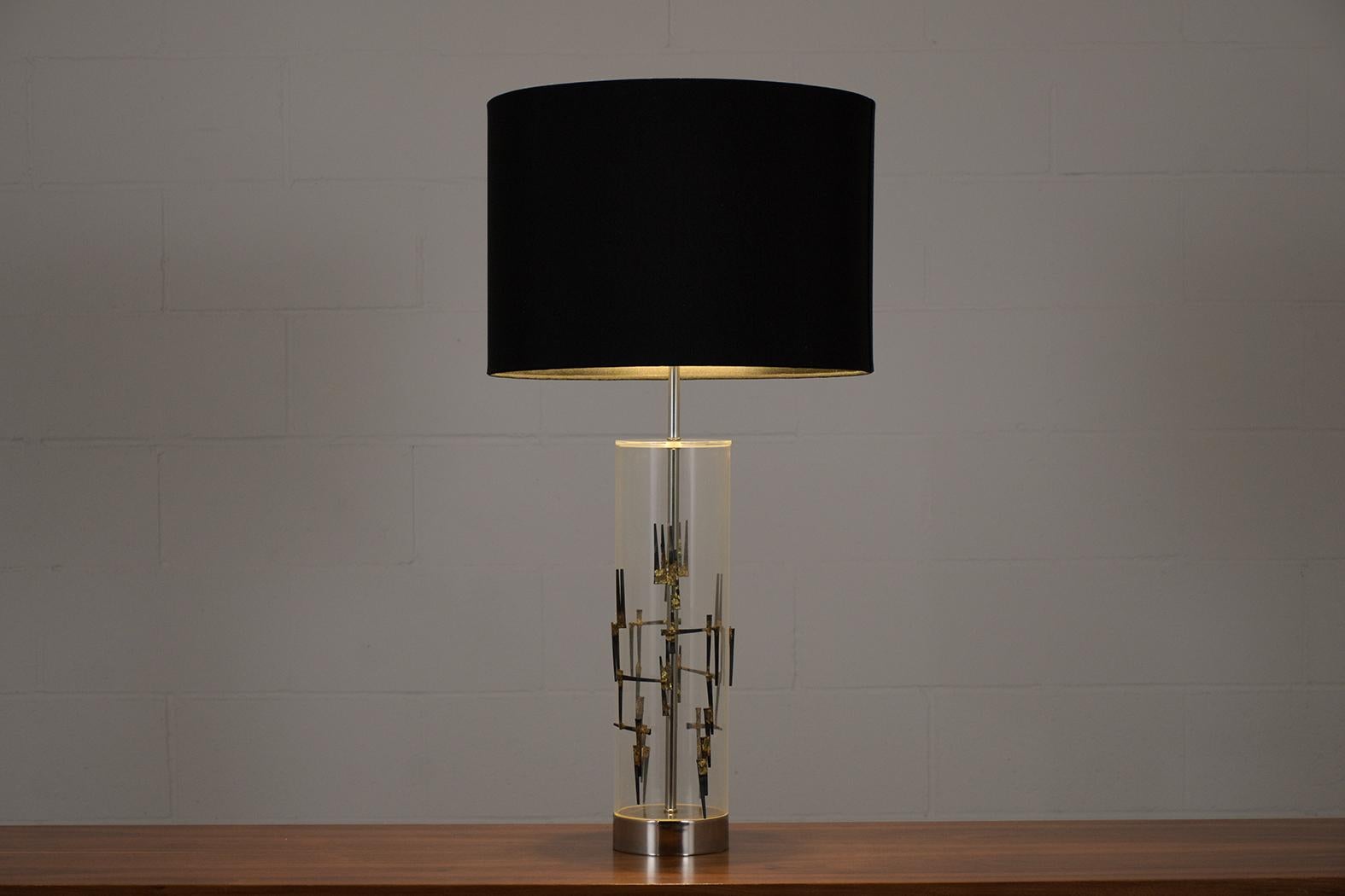 An extraordinary vintage mid-century modern lucite table lamp in great condition and newly restored by our team of expert craftsmen. The lamp is beautifully crafted out of lucite accentuated by sculptural ornaments making, has a sleek Brutalist