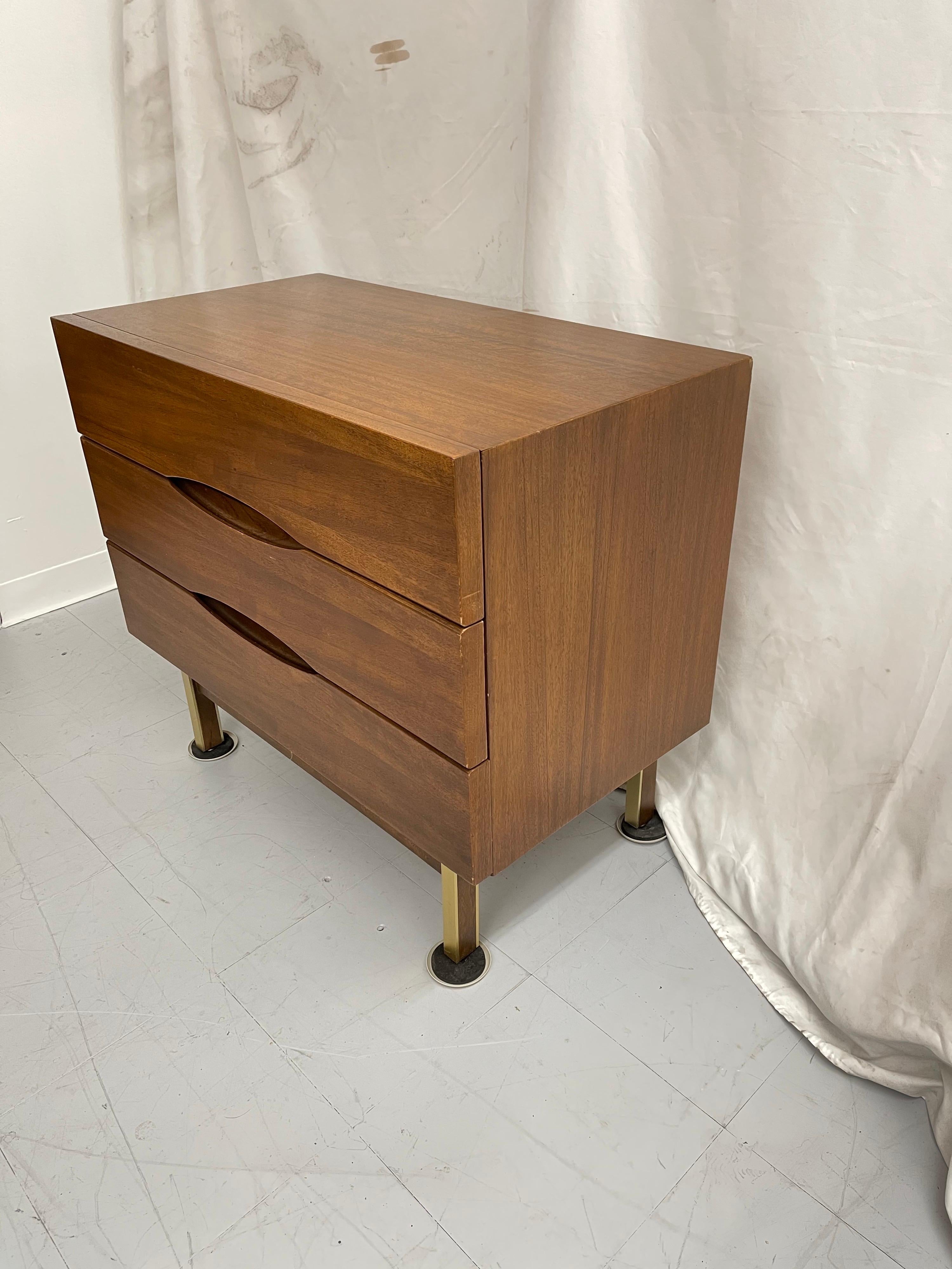 Clean lined three drawer dresser. Elliptical inset drawer openings and four brass-clad mahogany deeply recessed legs with high set mahogany stretchers.