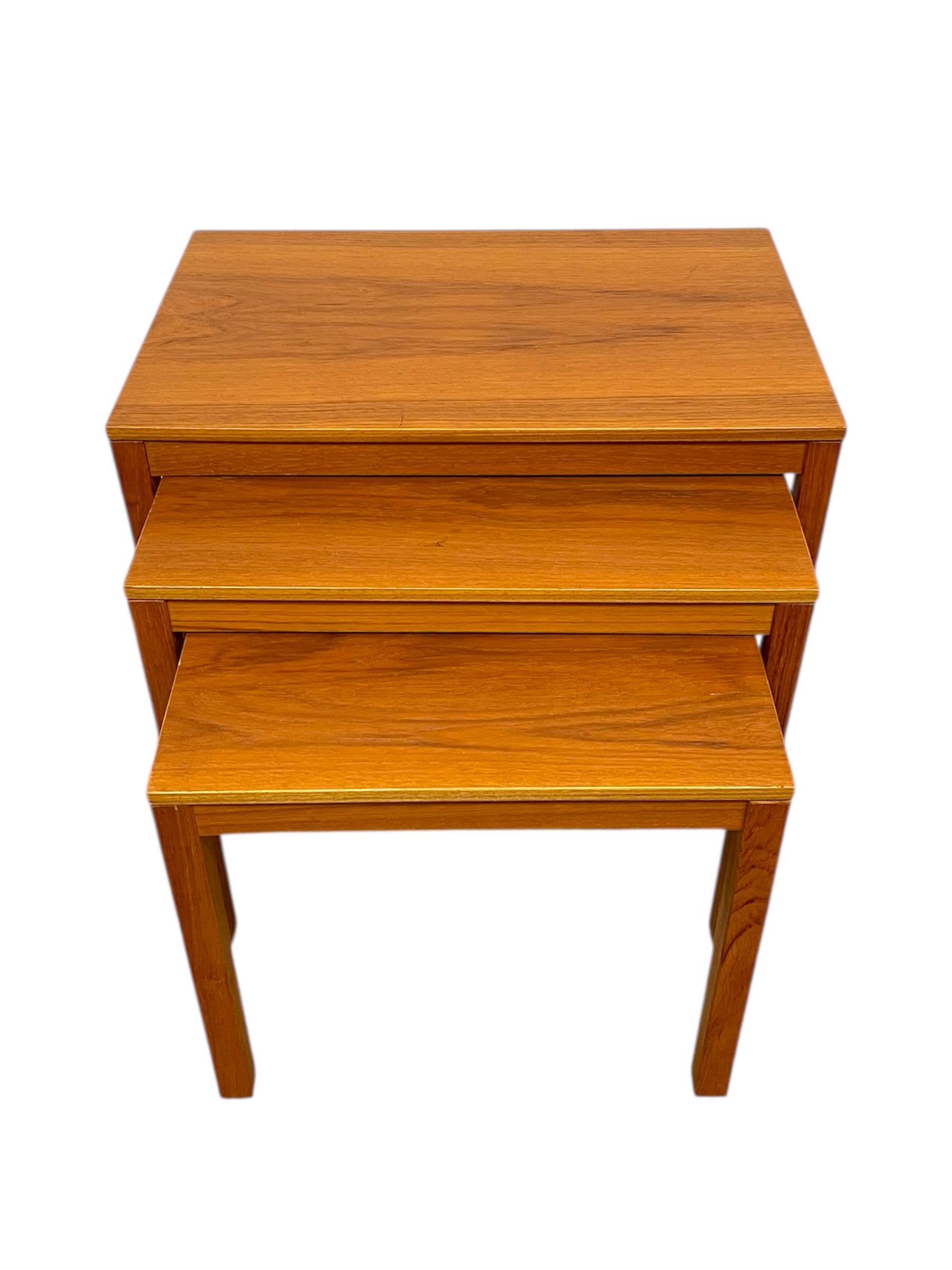  Elegant set of three vintage mid-century modern nesting tables. Designed with clean lines and precise joinery, these tables exemplify Scandinavian-inspired minimalism and functional versatility.Each table features a warm golden tone with rich