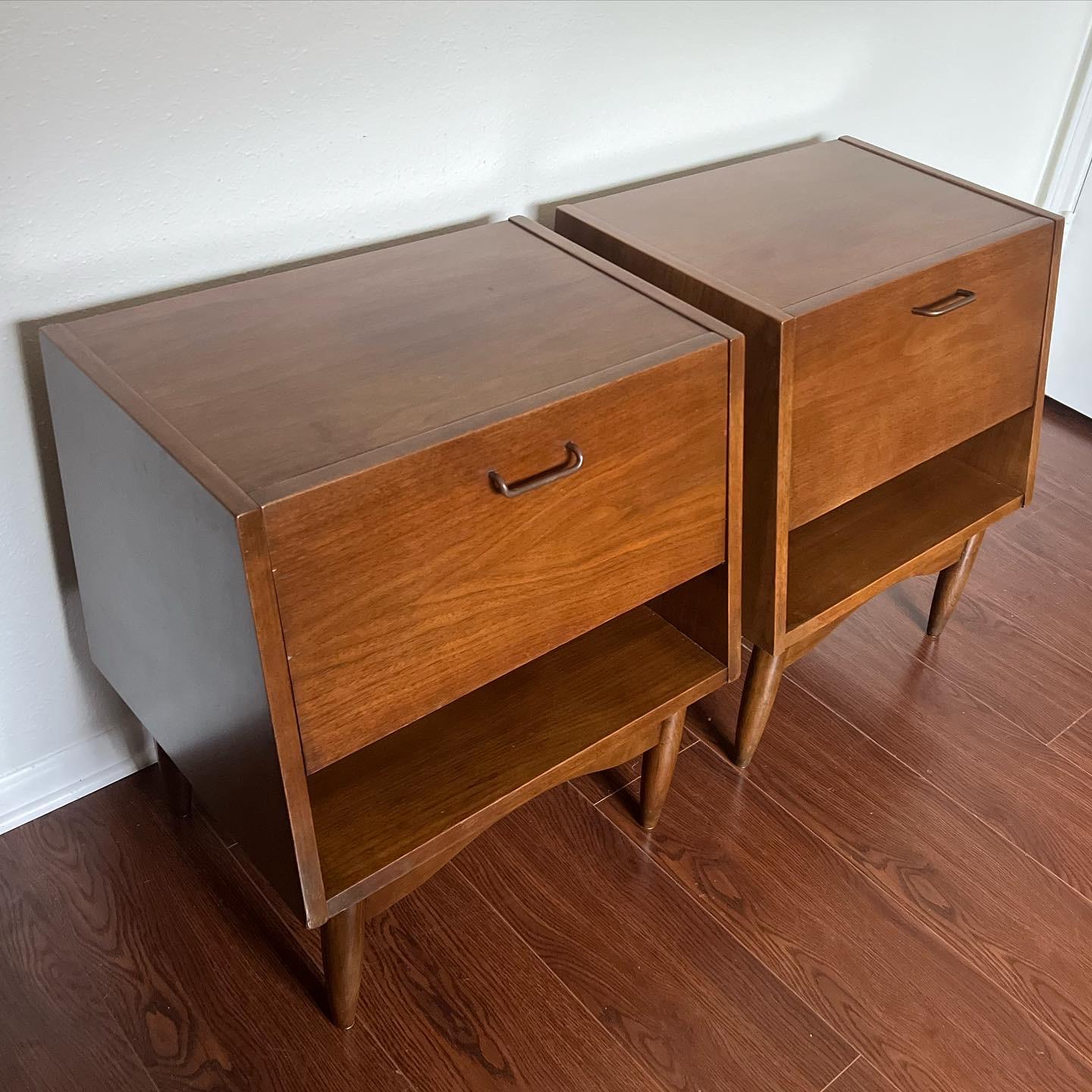 These Mid-Century Modern nightstands by American of Martinsville feature a unique bedside array of storage behind the stylish drop front cabinet. Iconic vintage style and storage perfect for any bedroom setting. In excellent condition.