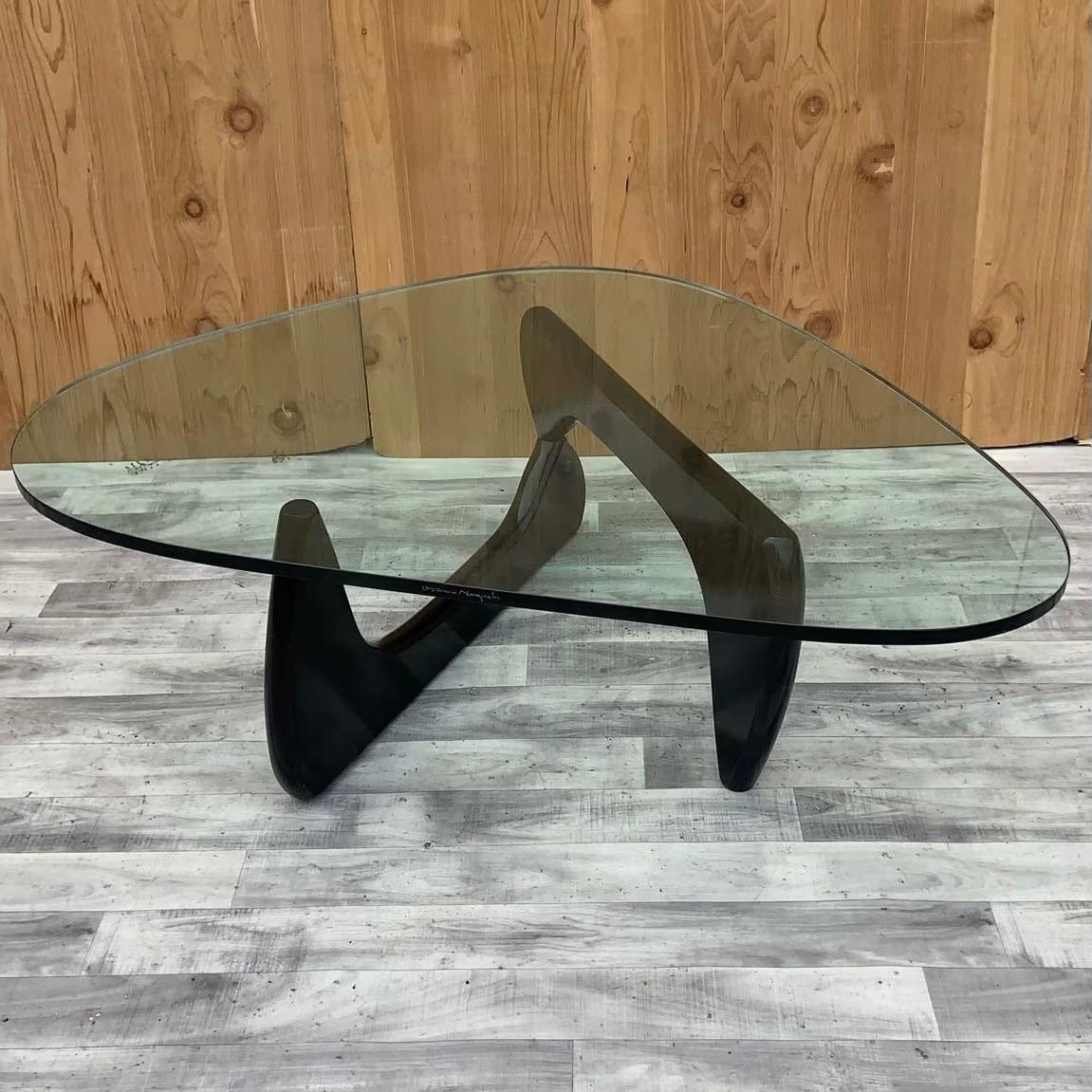 Vintage Mid Century Modern Noguchi Glass Top Coffee Table

This signed Isamu Noguchi Coffee table is a beautiful, simple design consists of only three elements, the glass top and two interlocking wood base pieces. This table was made by the table’s
