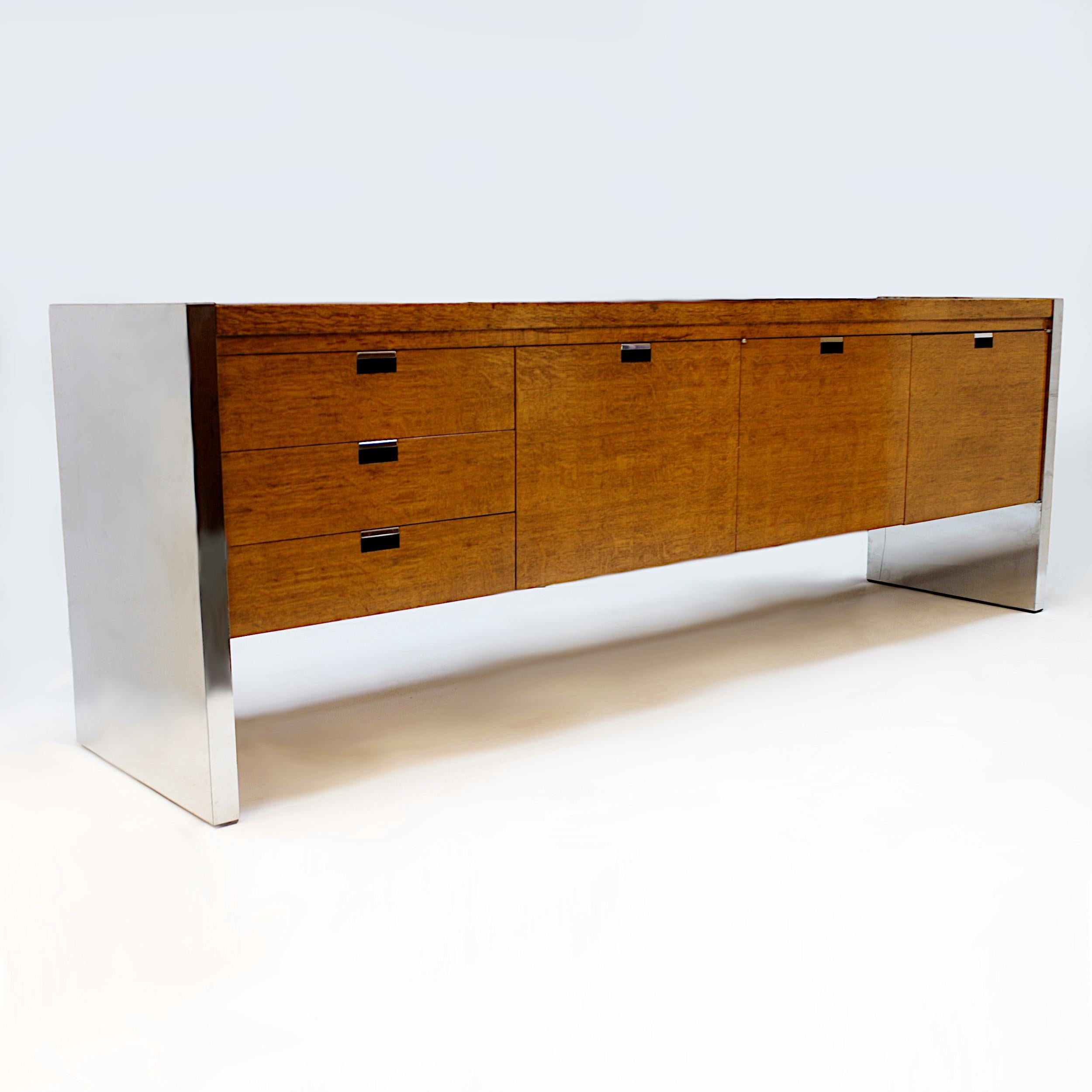 Impressive 1970s Credenza designed by Roger Sprunger for Dunbar. Credenza features gorgeous curly oak veneer, chrome ends, chrome pulls, and a wonderful minimalist design. This would make an excellent TV stand/console or would be right at home in an