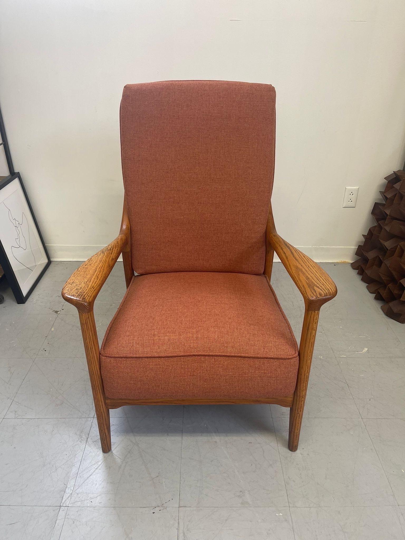 Oak Lounge Chair with Mid Century Modern Lines Throughout and Wood Slatted Back. This Chair Slightly Reclines as Shown In Picture.Recently Reupholstered in a textured Orange Fabric.

Dimensions. 27 W ; 33 1/2 D ; 37 H