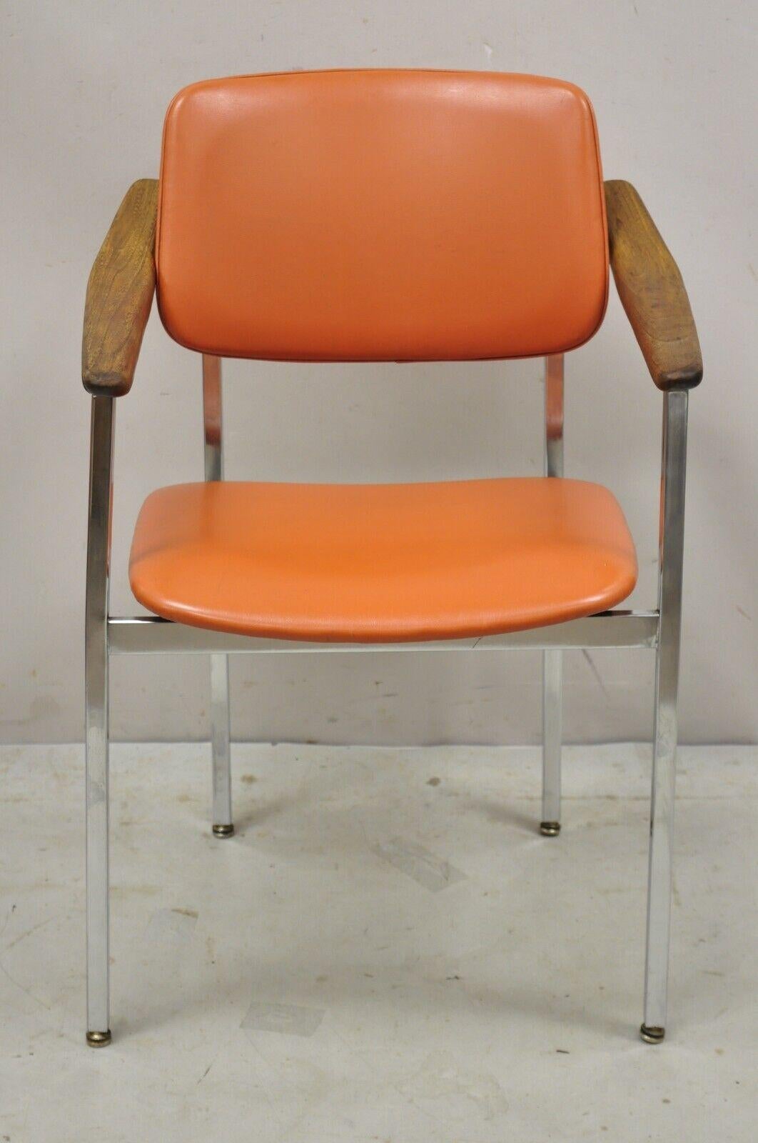 Vintage Mid-Century Modern orange chrome frame sloped wooden arm chair. Item features orange vinyl upholstery, chrome metal frame, sloped wooden arms, very nice vintage item, sleek sculptural form. circa mid to late 20th century. Measurements: 32.5