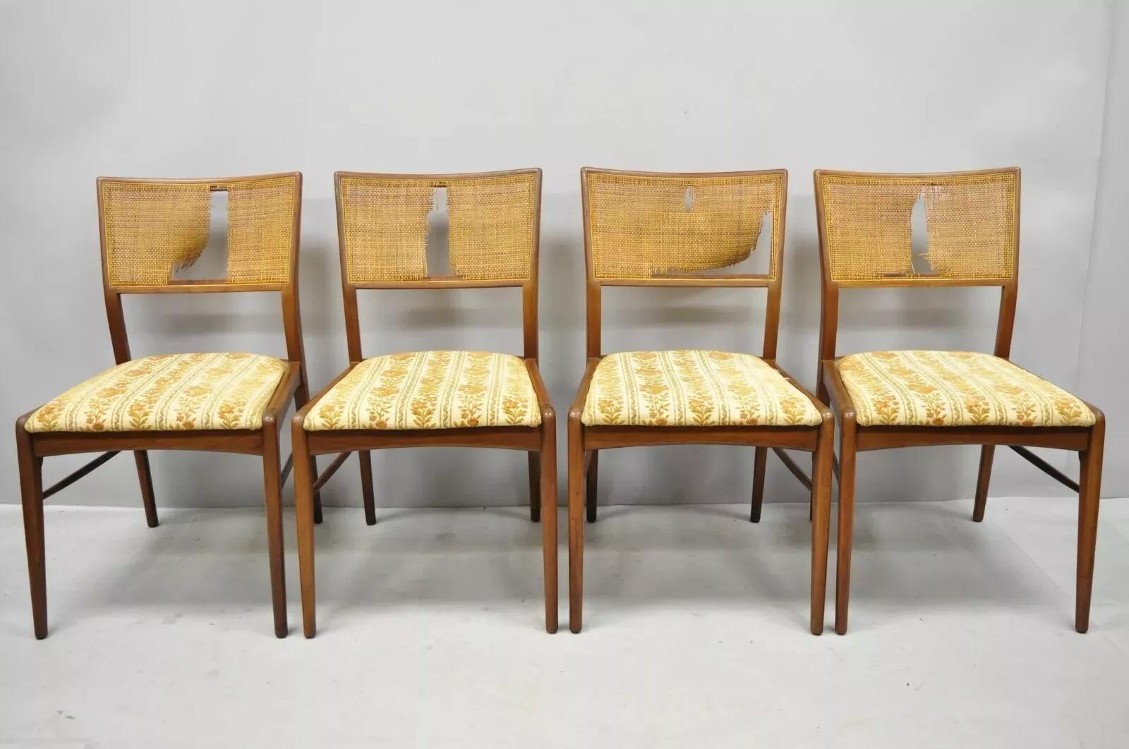 Vintage Mid Century Modern Paul McCobb Style Walnut Cane Dining Chairs - Set of 4. Item features cane backs, (4) side chairs, solid wood construction, beautiful wood grain, upholstered seat, tapered legs, sleek sculptural. Circa Mid 20th Century.