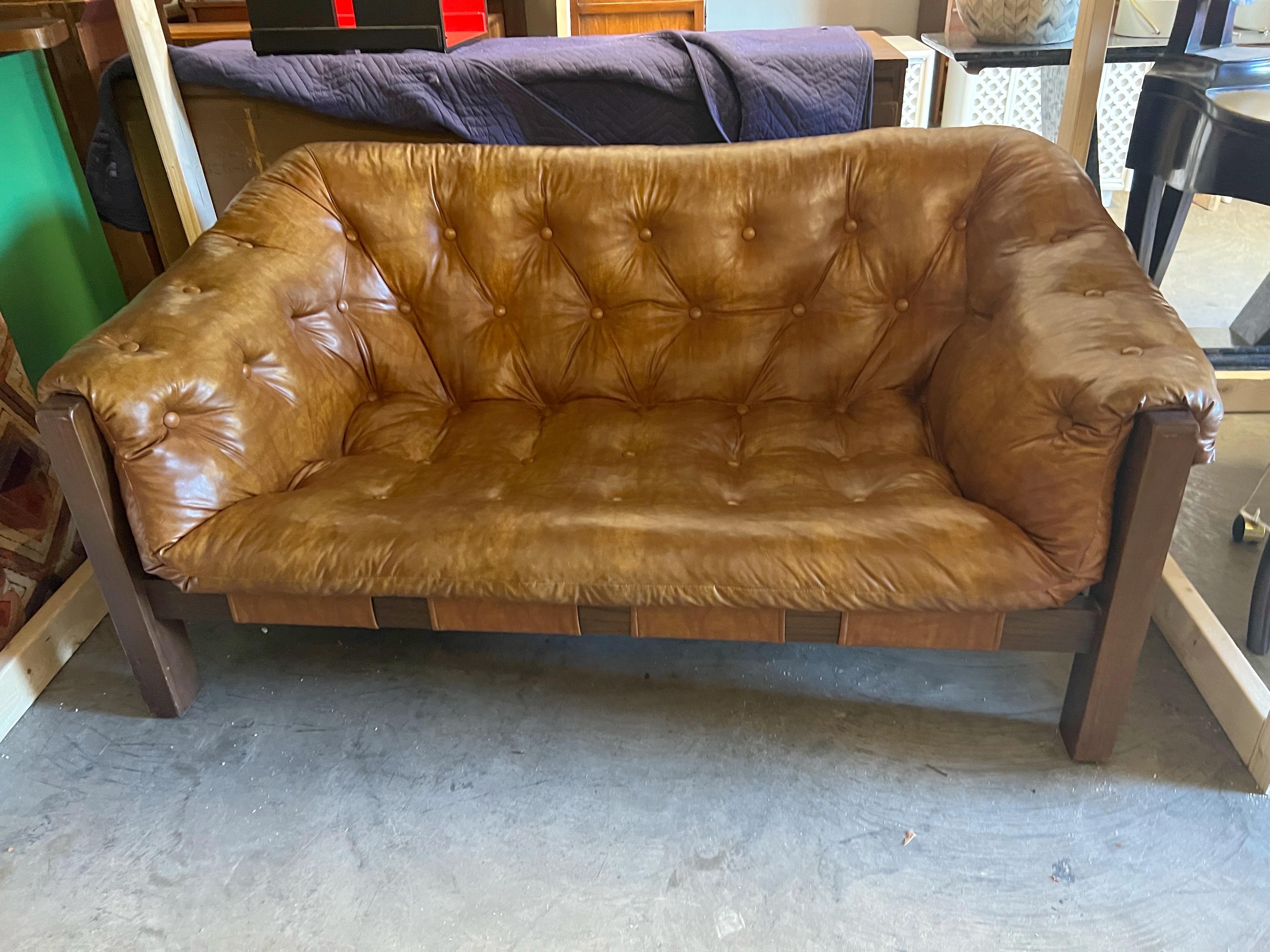 In a good vintage condition without any tear or damage. This beautiful piece features a walnut frame with tufted sling cushions. Both incredibly stylish as well as comfortable. Clean lines make this a wonderful addition to any modern living or