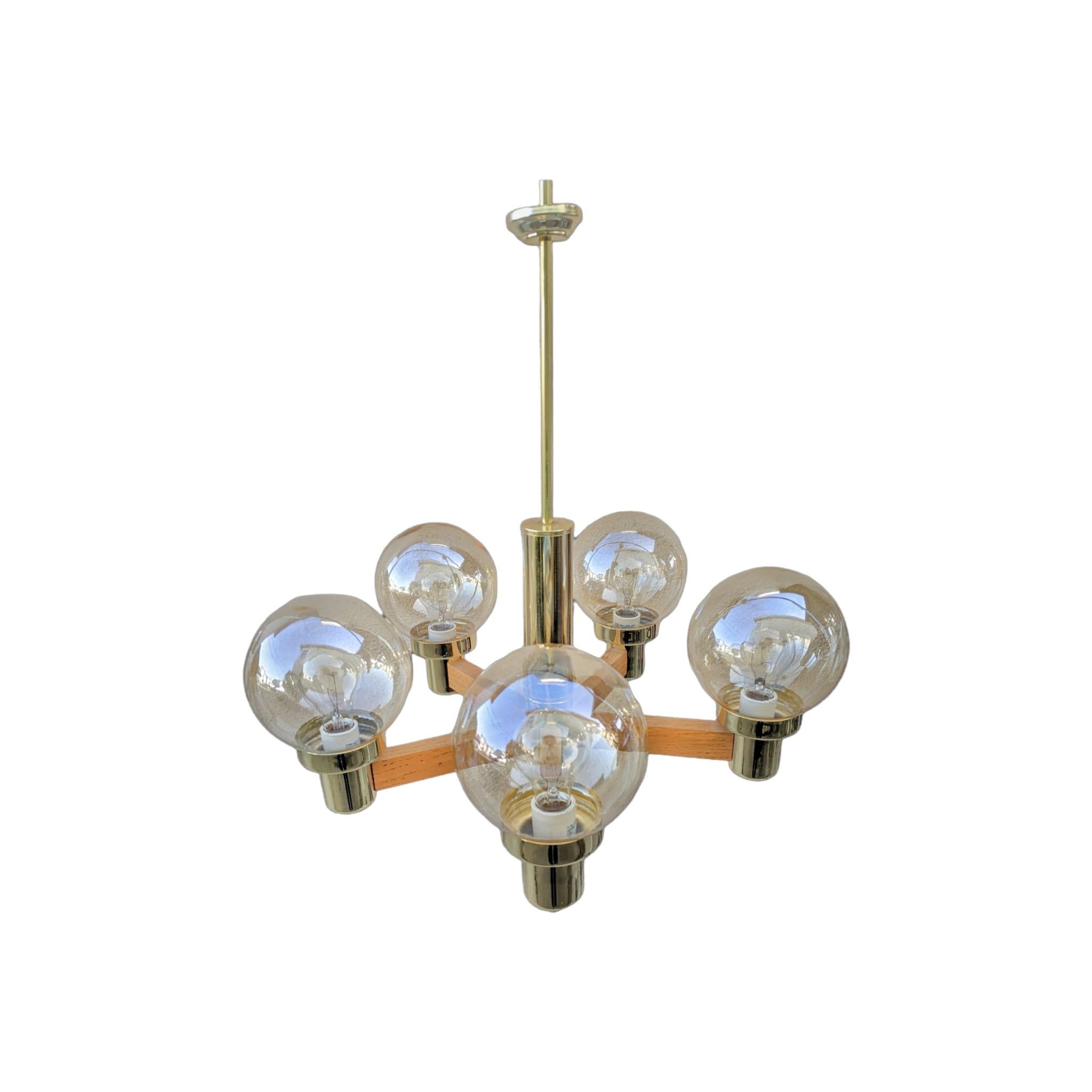This stunningly simple 5 arm modern globe chandelier features a lovely mix of materials: brass, wood, and a subtly iridescent smoky glass. It s a piece from late in the Mid-Century Modern era, and one can see the transitional elements in the chunky