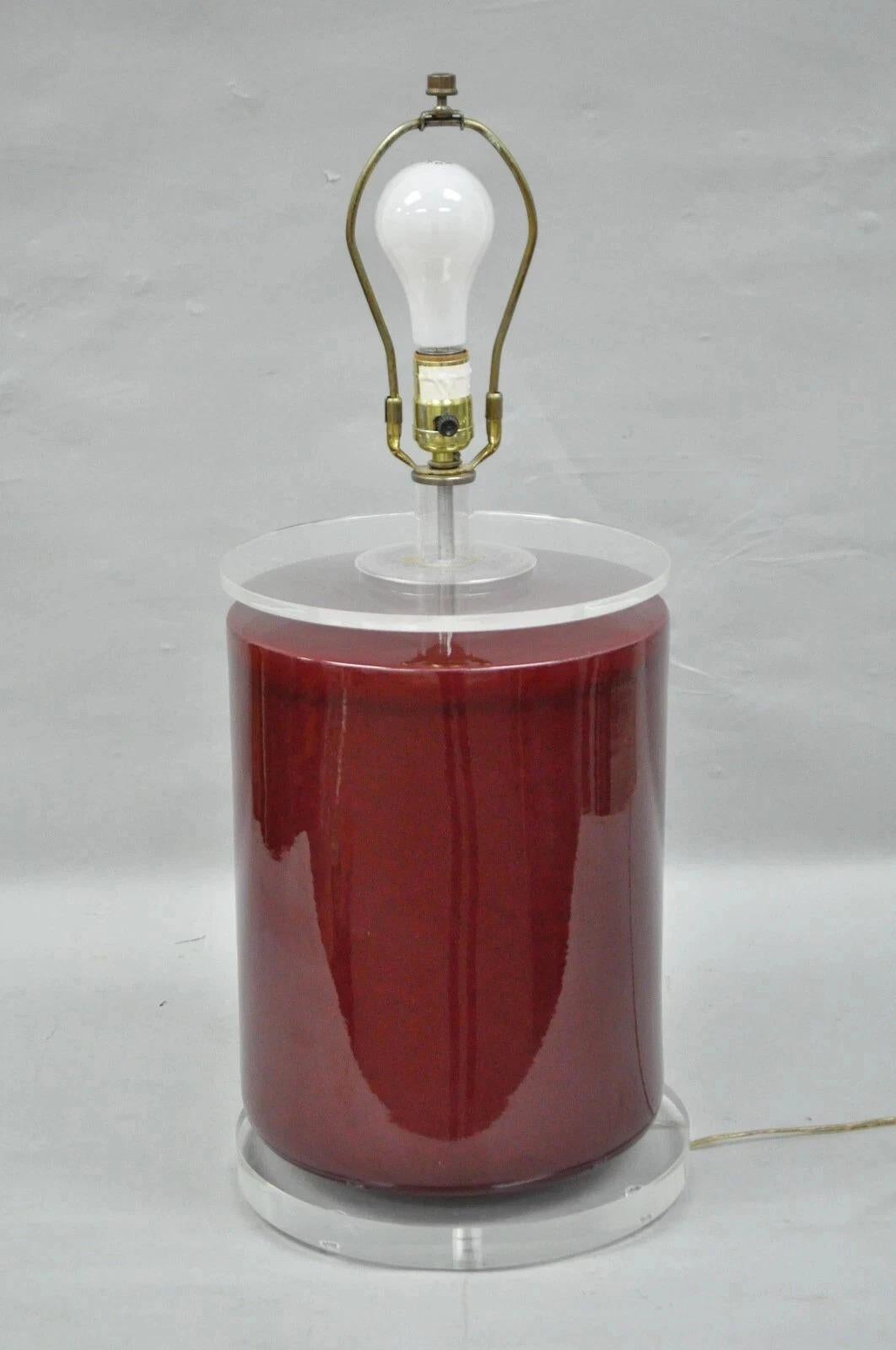 Vintage Mid Century Modern Red Ceramic Cylinder & Lucite Modernist Table Lamp. Item features a round red speckle finished ceramic body, clear lucite top and base, great modernist form. Circa Mid 20th Century. Measurements: 26