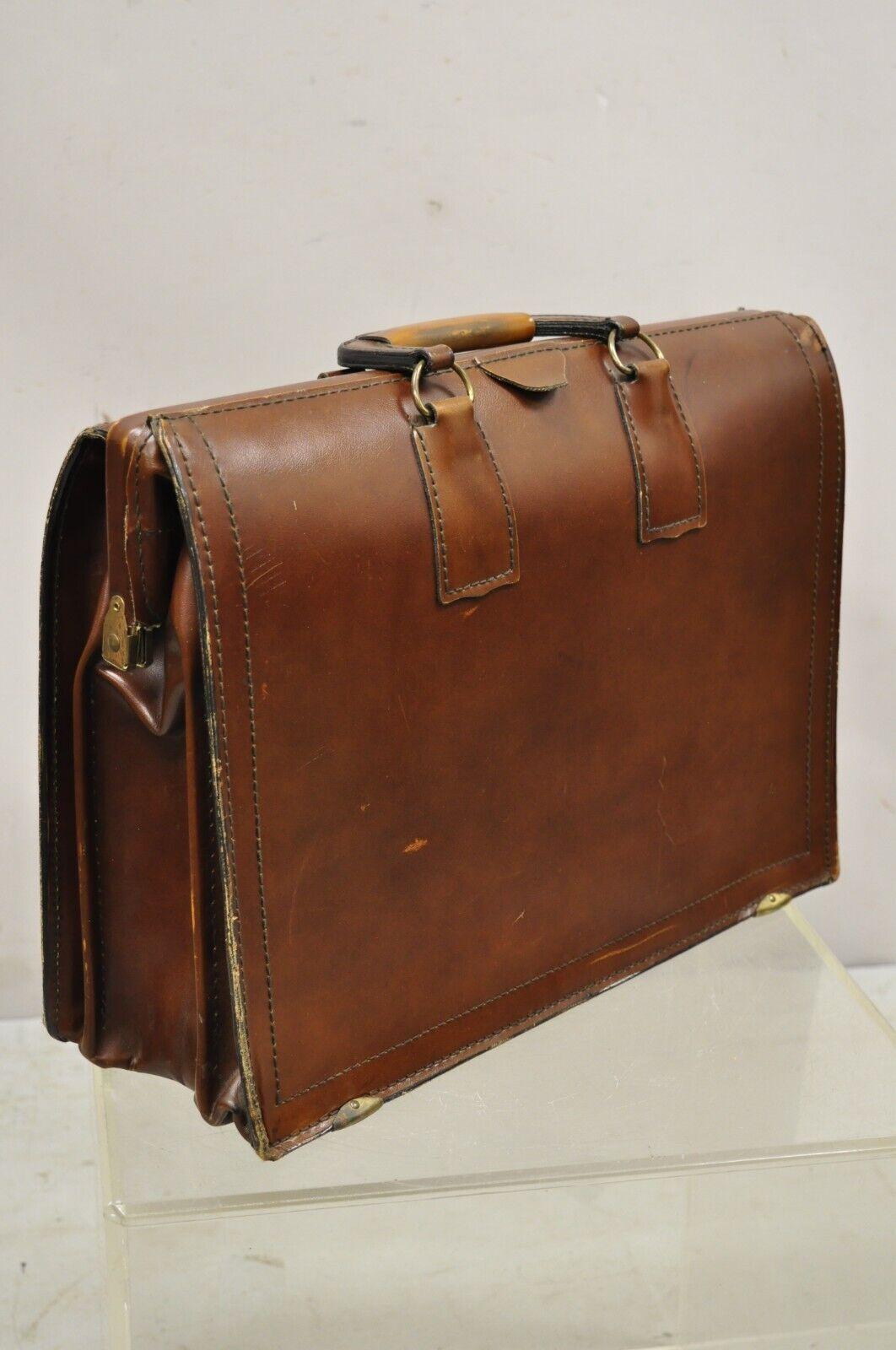 Vintage Mid-Century Modern saddle leather briefcase case by Lion Leather Prods. Item features a beautiful burnished brown style leather, twin handles, two interior side slots/pockets, quality American craftsmanship, circa Mid to late 20th century.