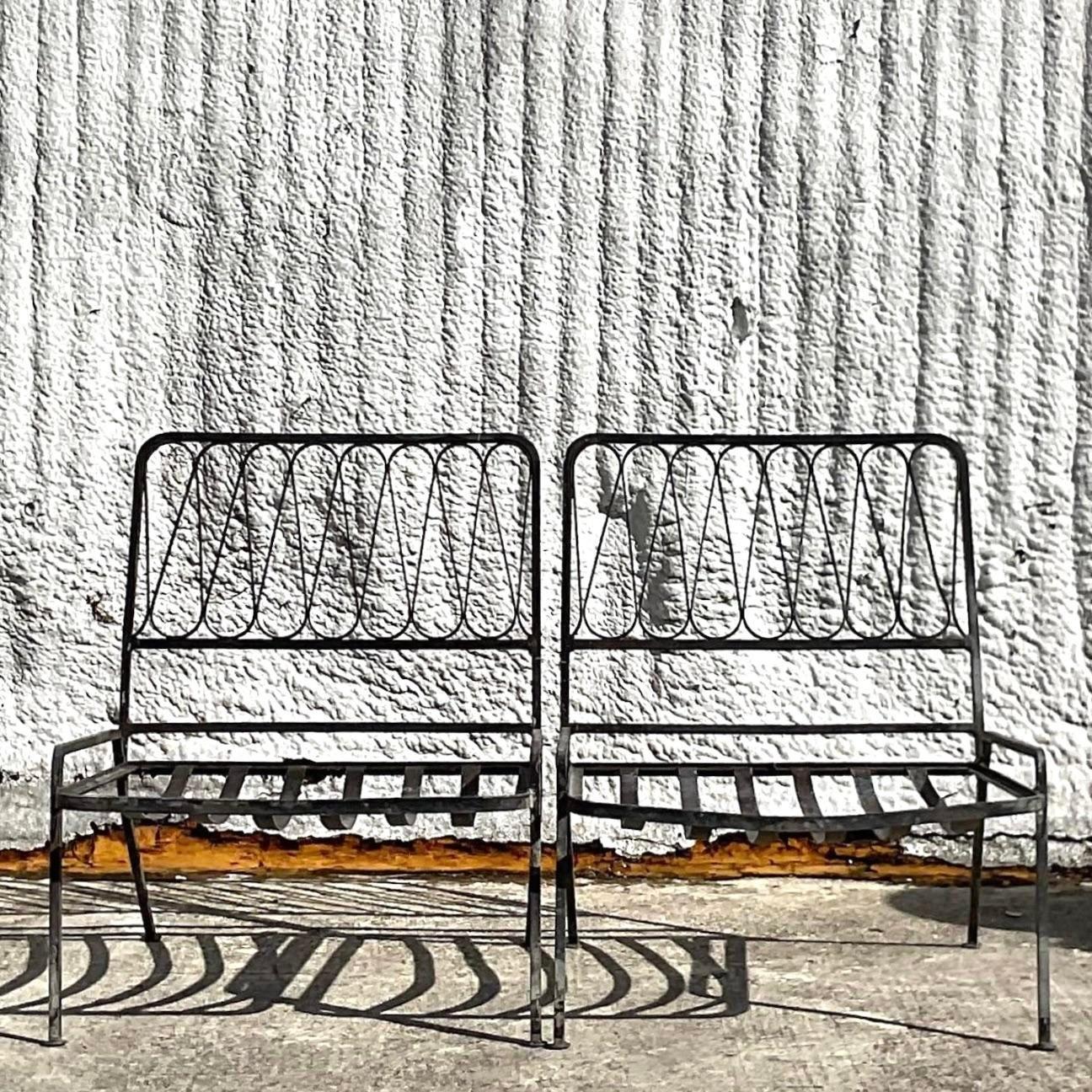 Une fabuleuse paire de chaises pantoufles vintage en fer forgé MCM. Fabriqué par l'emblématique groupe Salterini. Non marqué. Le style classique du ruban dans une forme épurée et moderne. Acquis d'une propriété de Palm Beach.