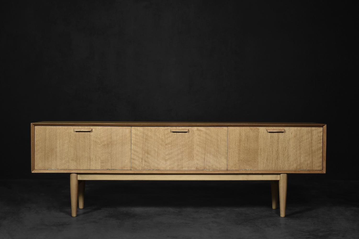 This classic sideboard was made in Denmark during the 1970s. It was finished with oak wood, highly valued in the northern regions of Europe, with regular and clean grain and a natural, straw color. The wood was additionally waxed, which emphasized