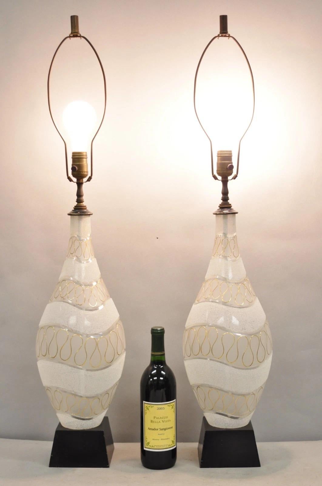 Paire de lampes de table Vintage Mid Century Modern en verre dépoli sculpté au design ondulé doré sur base en métal peint en noir. Circa Mid 20th Century. Dimensions : 37