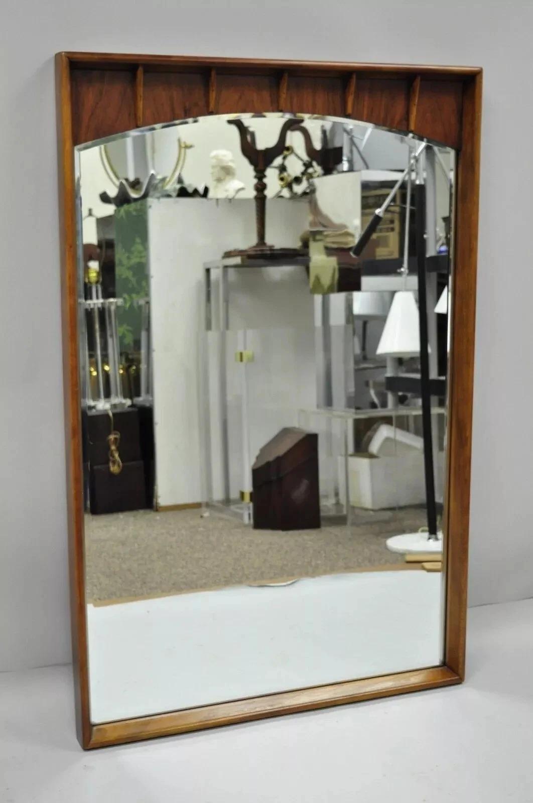 Vintage Mid Century Modern Sculptured Walnut & Rosewood Beveled Glass Wall Mirror attributed to Lane. L'article se caractérise par une construction en bois massif, un magnifique grain de bois, un cachet original et une fabrication américaine de