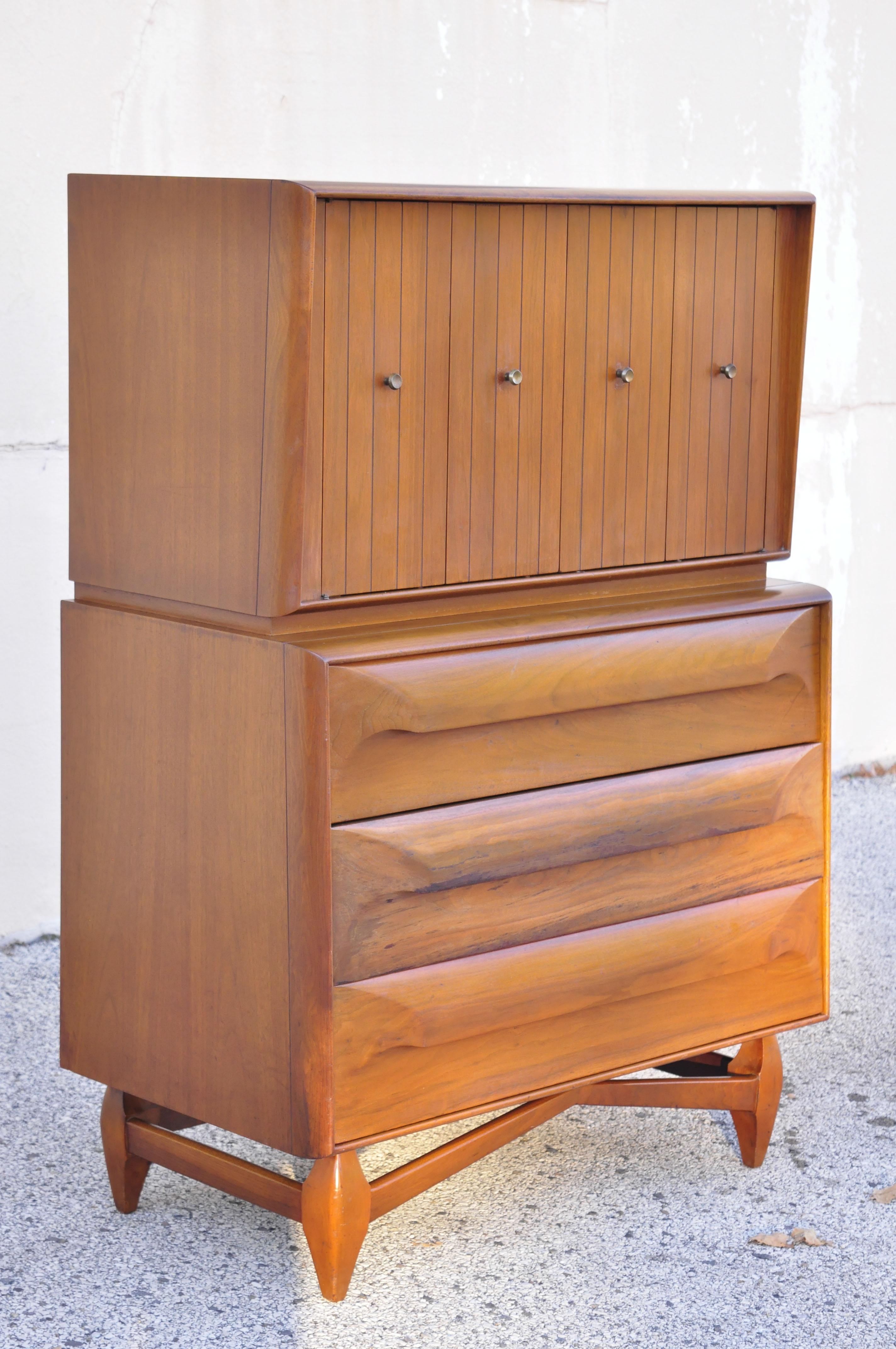 Commode haute en noyer de style danois, sculpturale et moderne du milieu du siècle dernier. Cet article se caractérise par une base en bois sculpté, des pieds sculptés, des portes battantes à deux battants, un magnifique grain de bois, 6 tiroirs, un