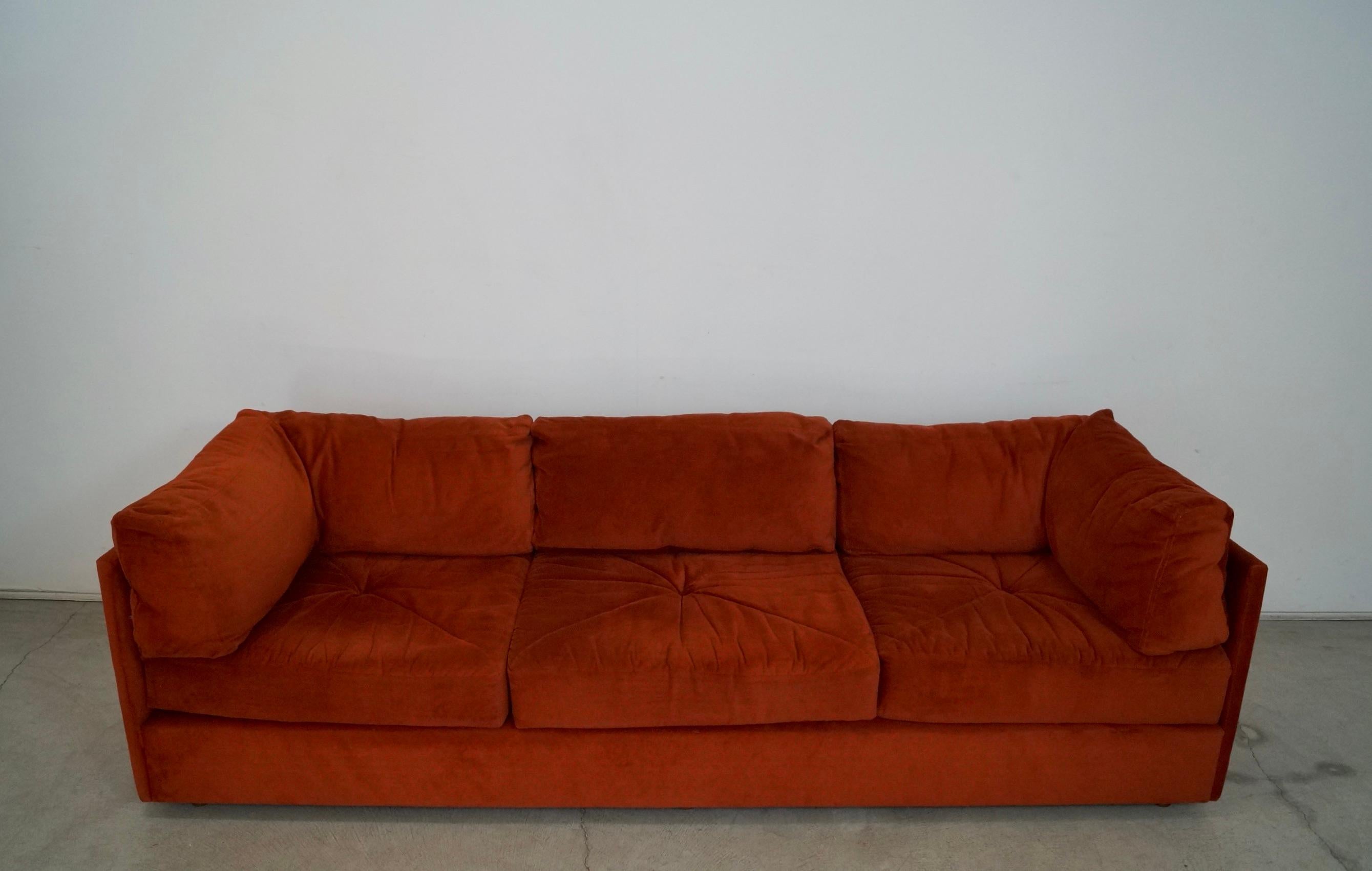 Vintage Midcentury Modern lounge couch for sale. Manufactured by Selig, and is a design classic. Has the original rust burnt orange fabric in a soft velveteen fabric in excellent vintage condition. Comes with six cushions, and all have zippers that