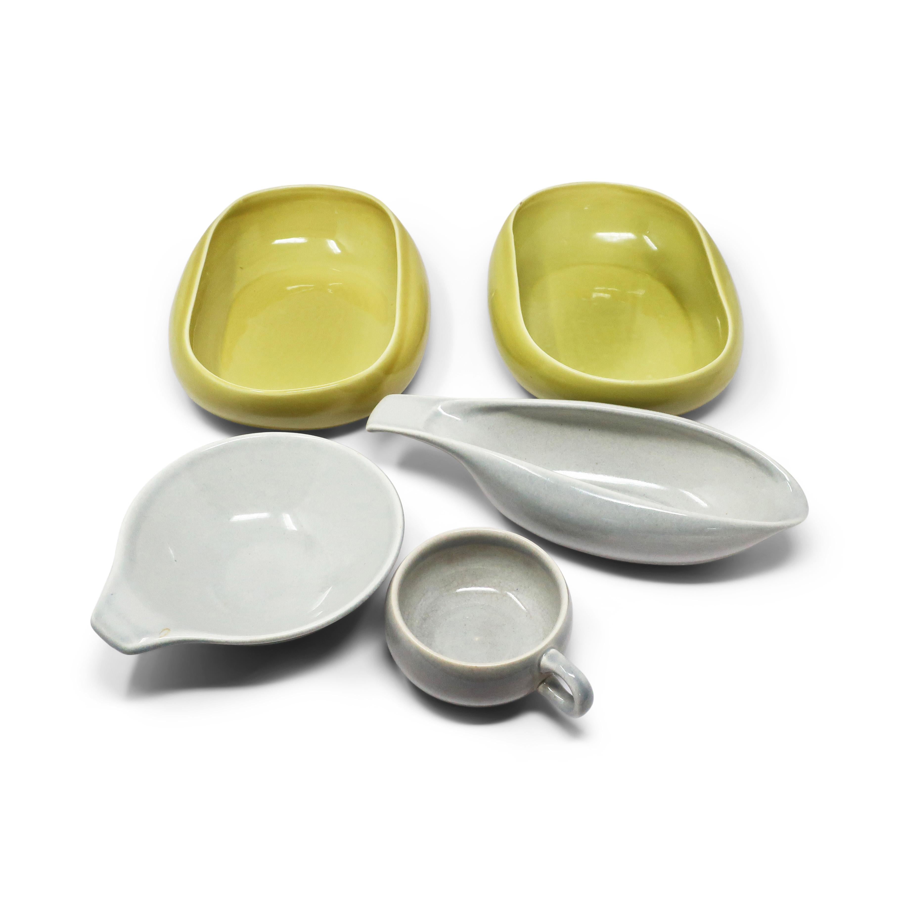 A five piece collection of vintage Russell Wright for Steubenville ceramic serving pieces. Mid century modern design at its best in light grey and green. Two large serving bowls, one that looks like a gravy boat, one small serving bowl, and a tea