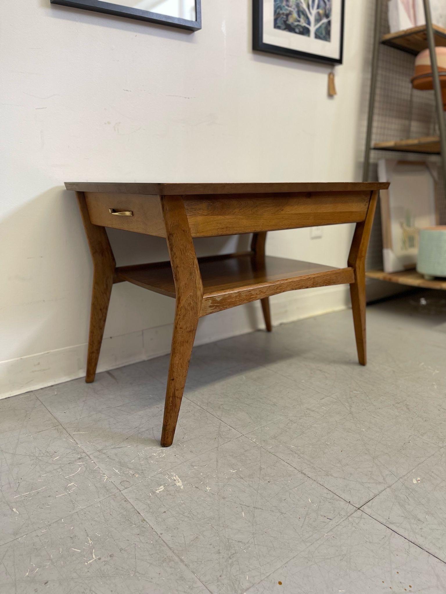 This End Table has an atomic shape to the legs, Classic 1960s design. Single Dovetailed drawer with makers mark inside. Cool wood grain, honey walnut tone. Vintage Condition Consistent with Age as Pictured.

Dimensions. 31 W ; 19 D ; 22 H
