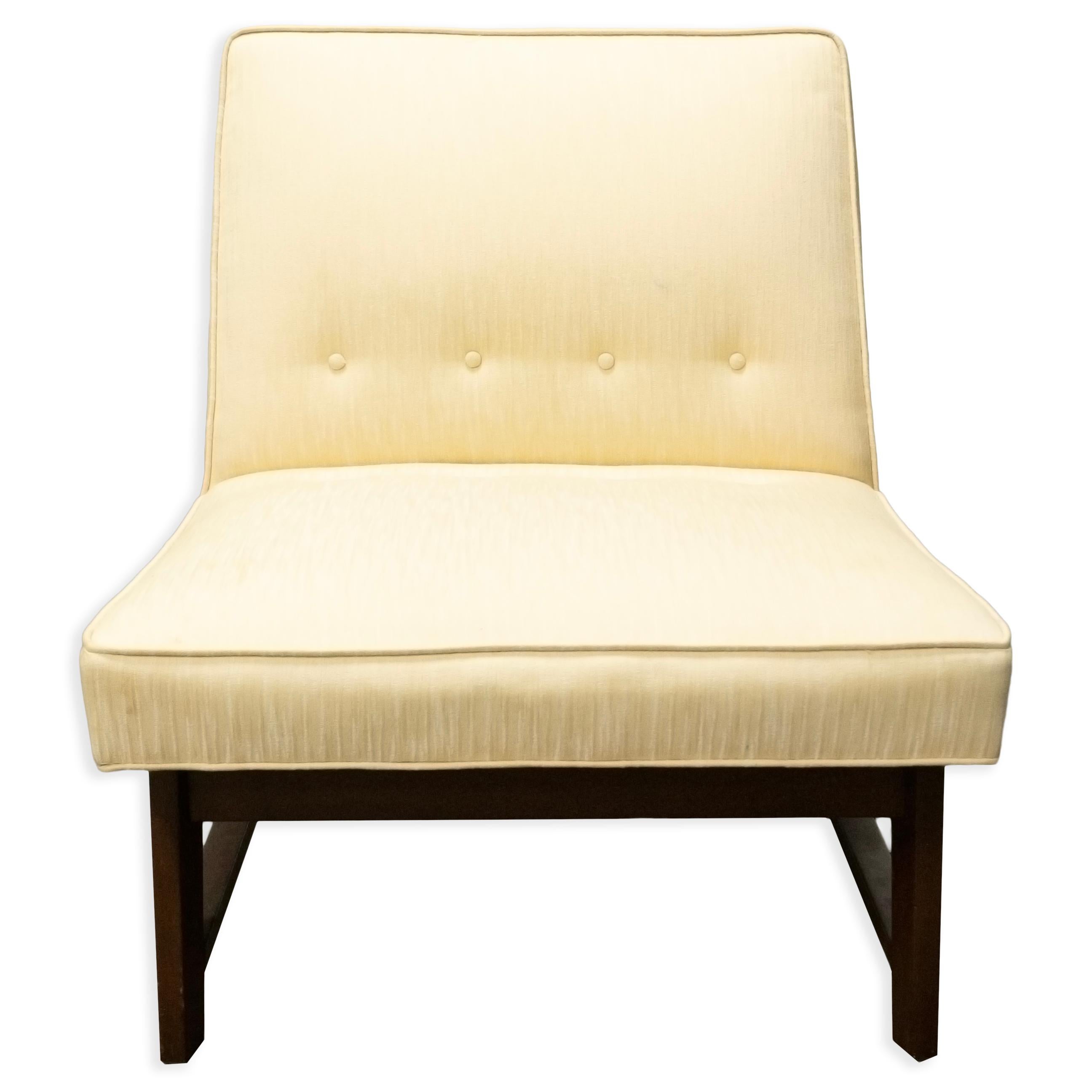 This is a yellow upholstered slipper chair designed in the style of Edward Wormley for Dunbar. Its unique silhouette and lower profile make it a stunning mid-century modern piece, perfect for a living room or as an accent chair in a bedroom. The
