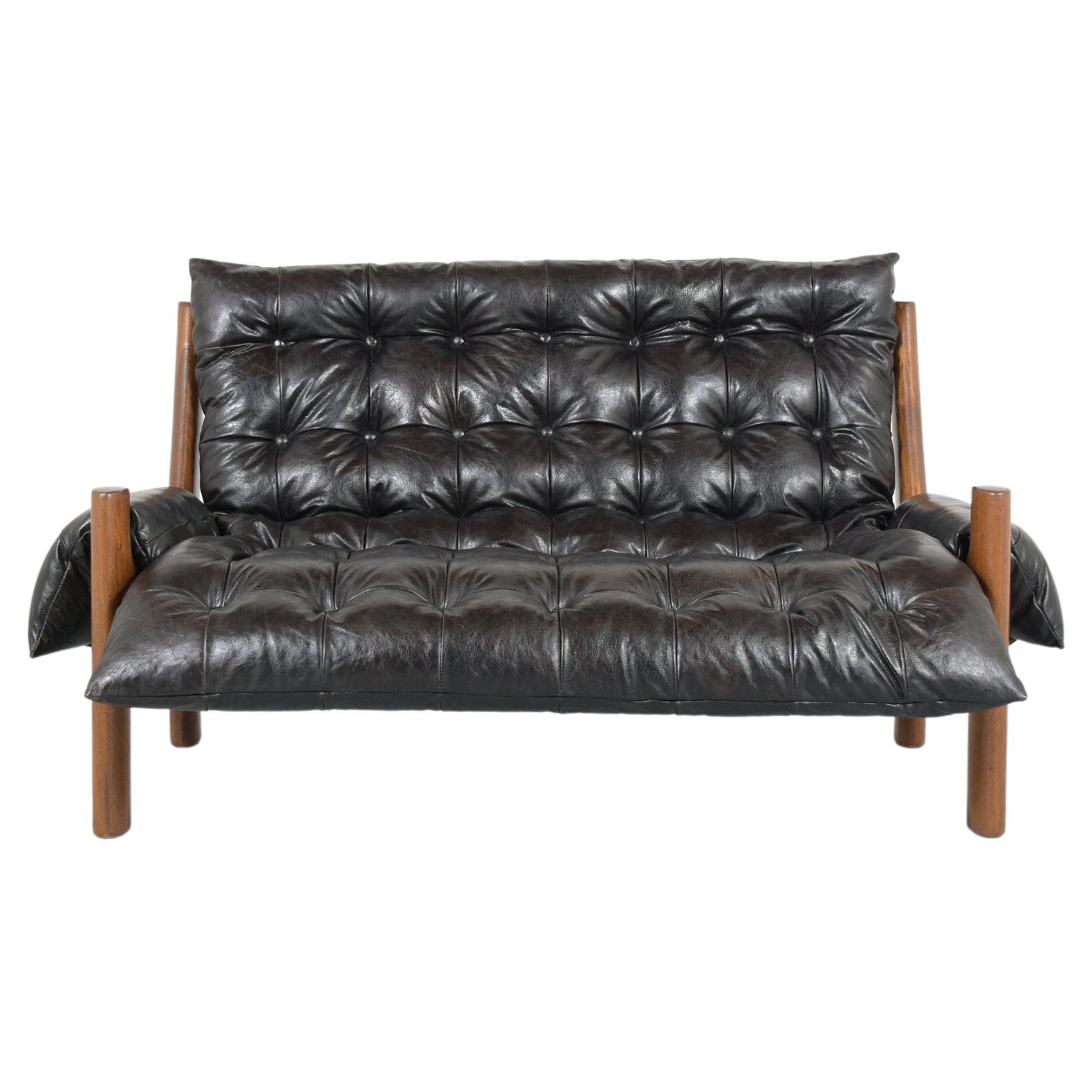 This extraordinary vintage mid-century modern sofa in the manner of Sergio Rodrigues is crafted out of teak wood in good condition and has been newly restored by our team of expert craftsmen. This sofa is composed of a solid rounded teak wood frame,